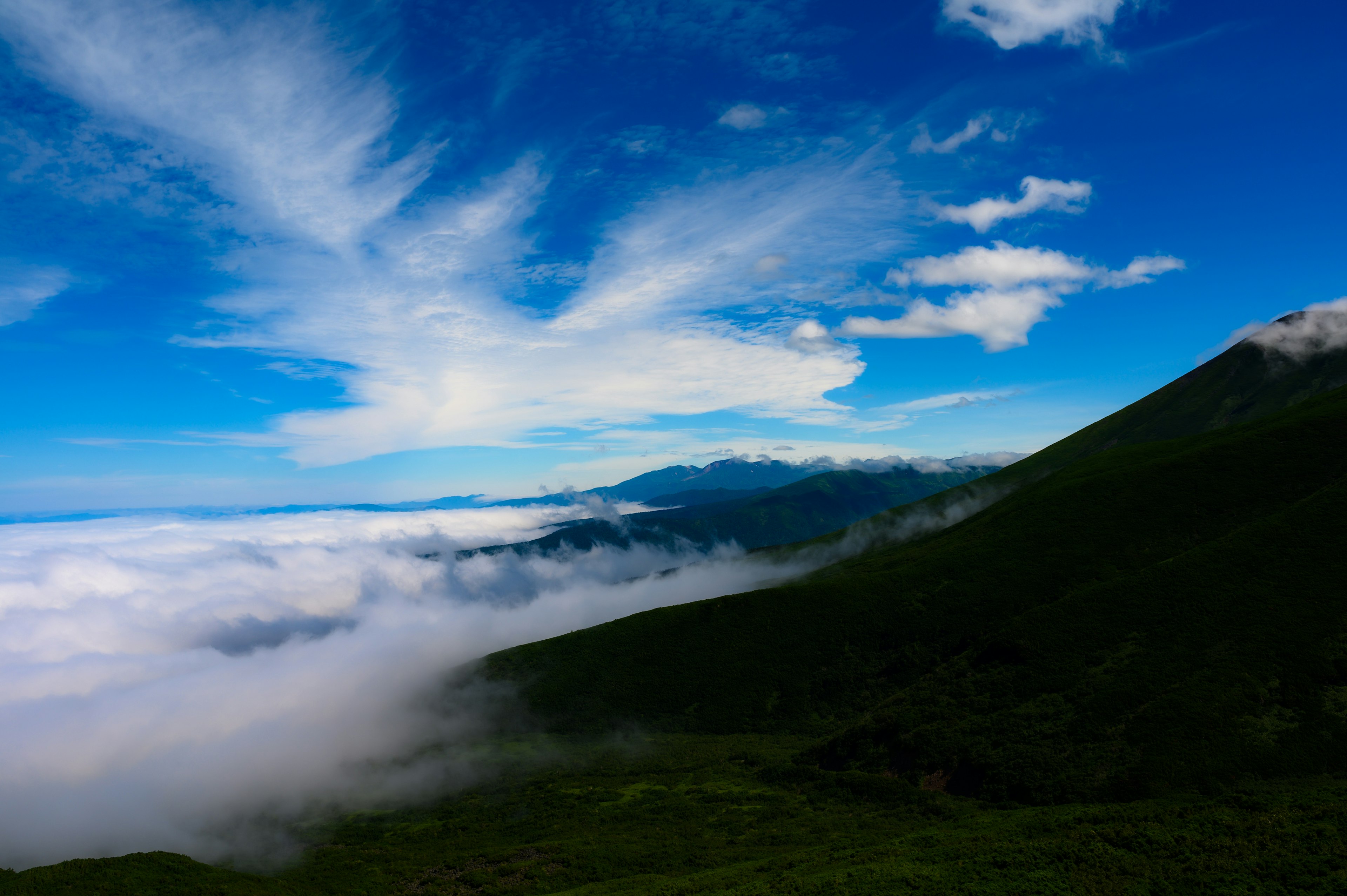 青い空と雲海の風景 山のシルエットが見える