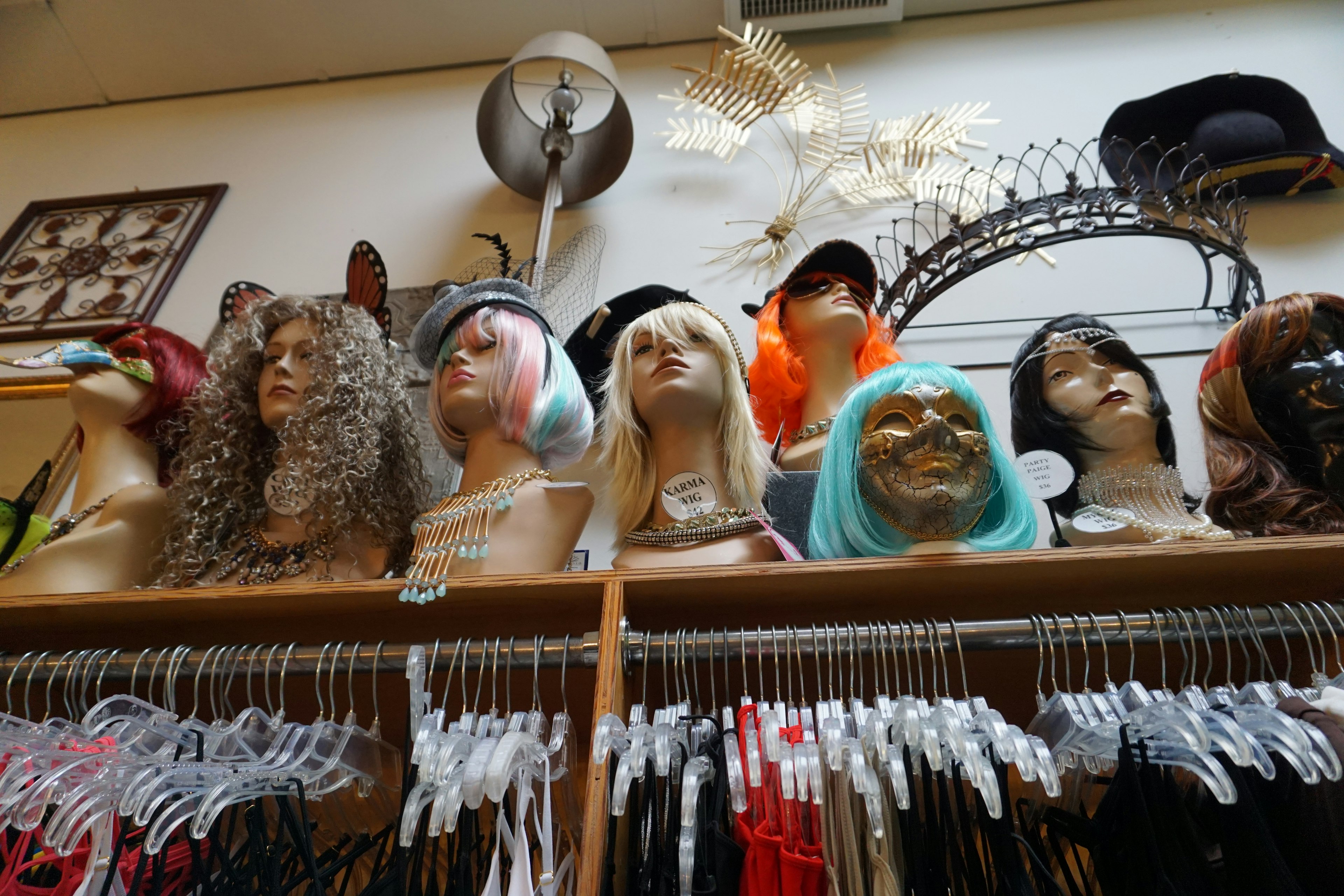 Display of various wigs on mannequin heads in a shop