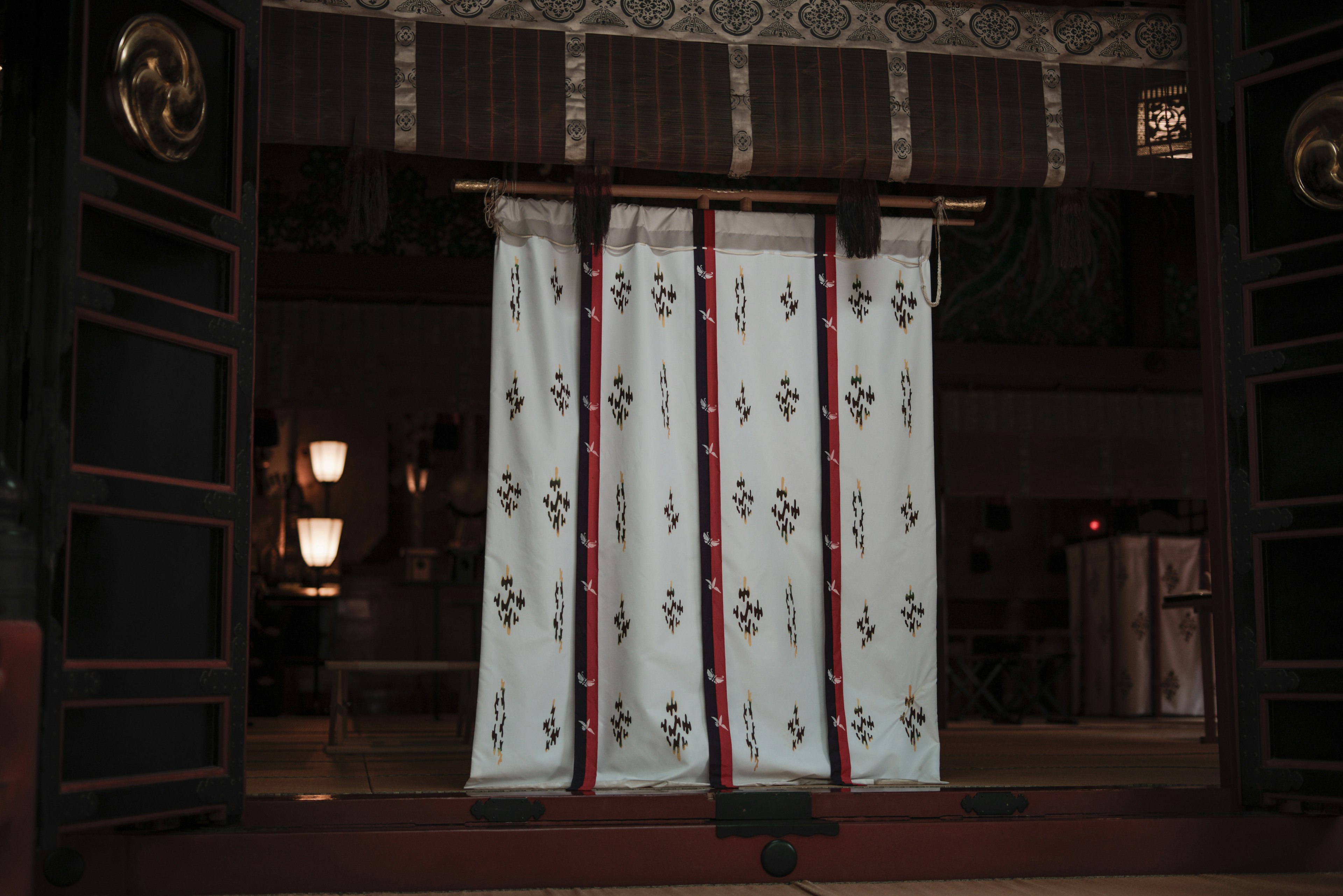 Traditional Japanese entrance with white noren curtains featuring red patterns