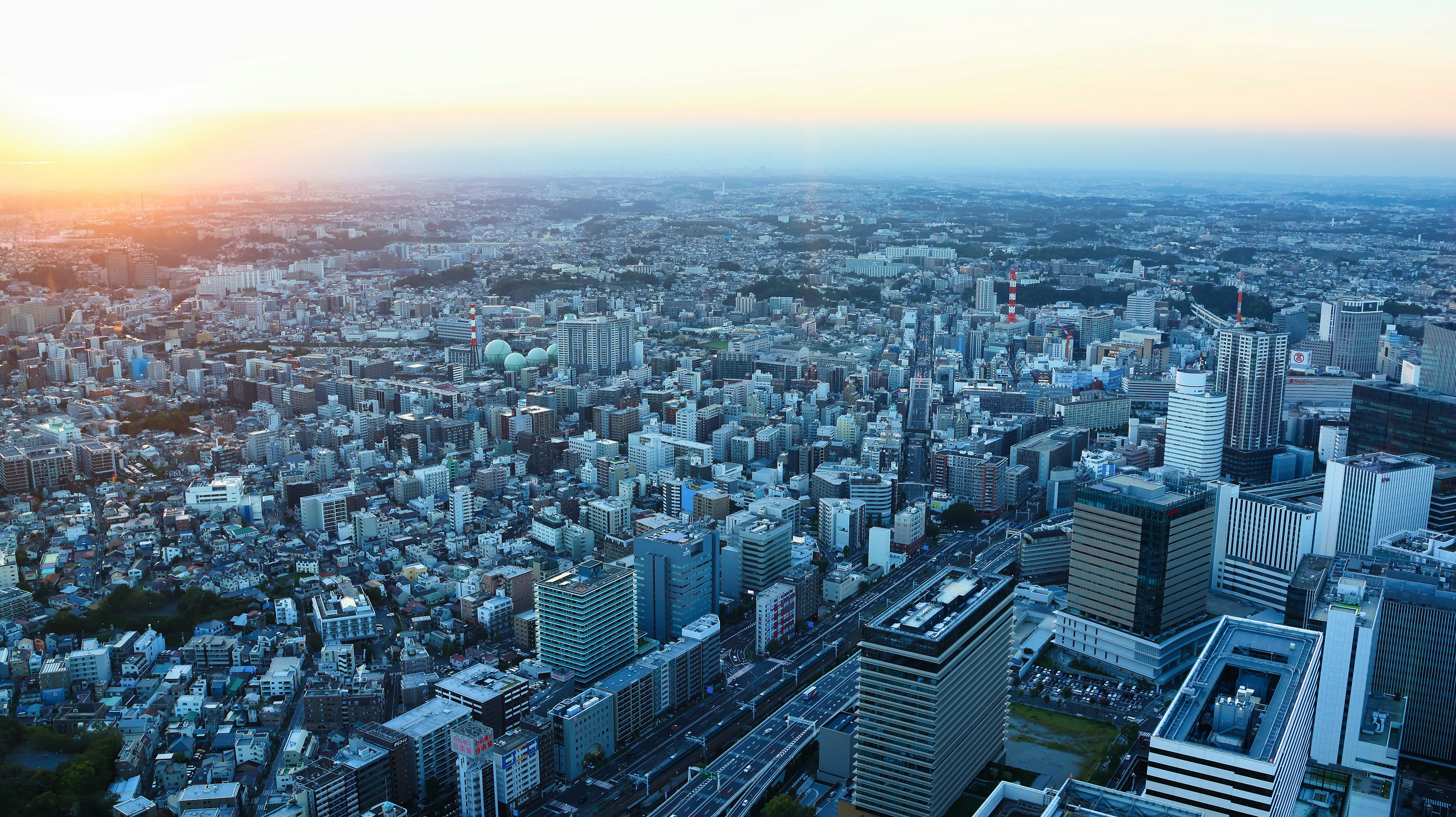 Panoramic view of a sprawling cityscape with sunset lighting