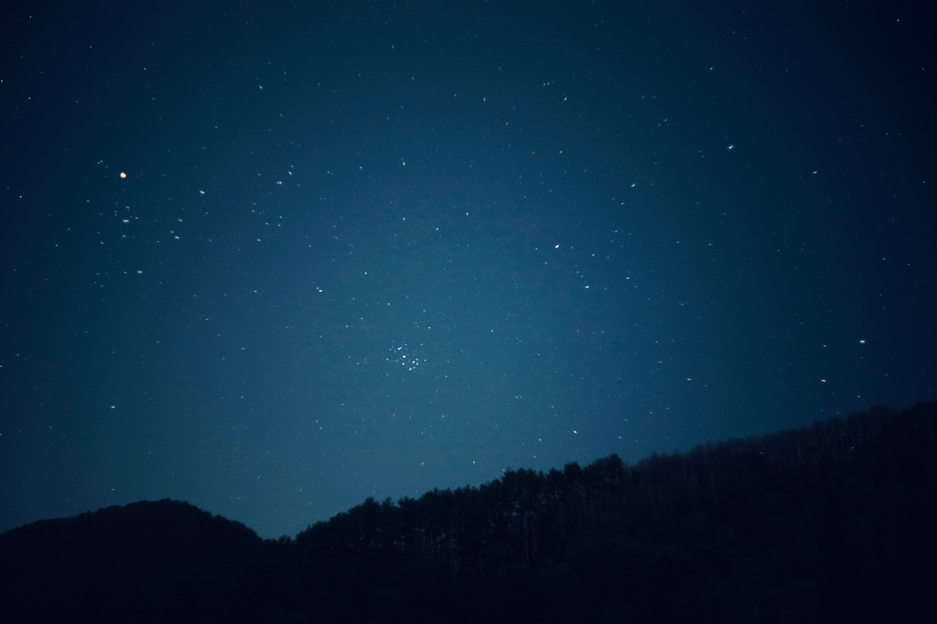 夜空に輝く星々と山のシルエット