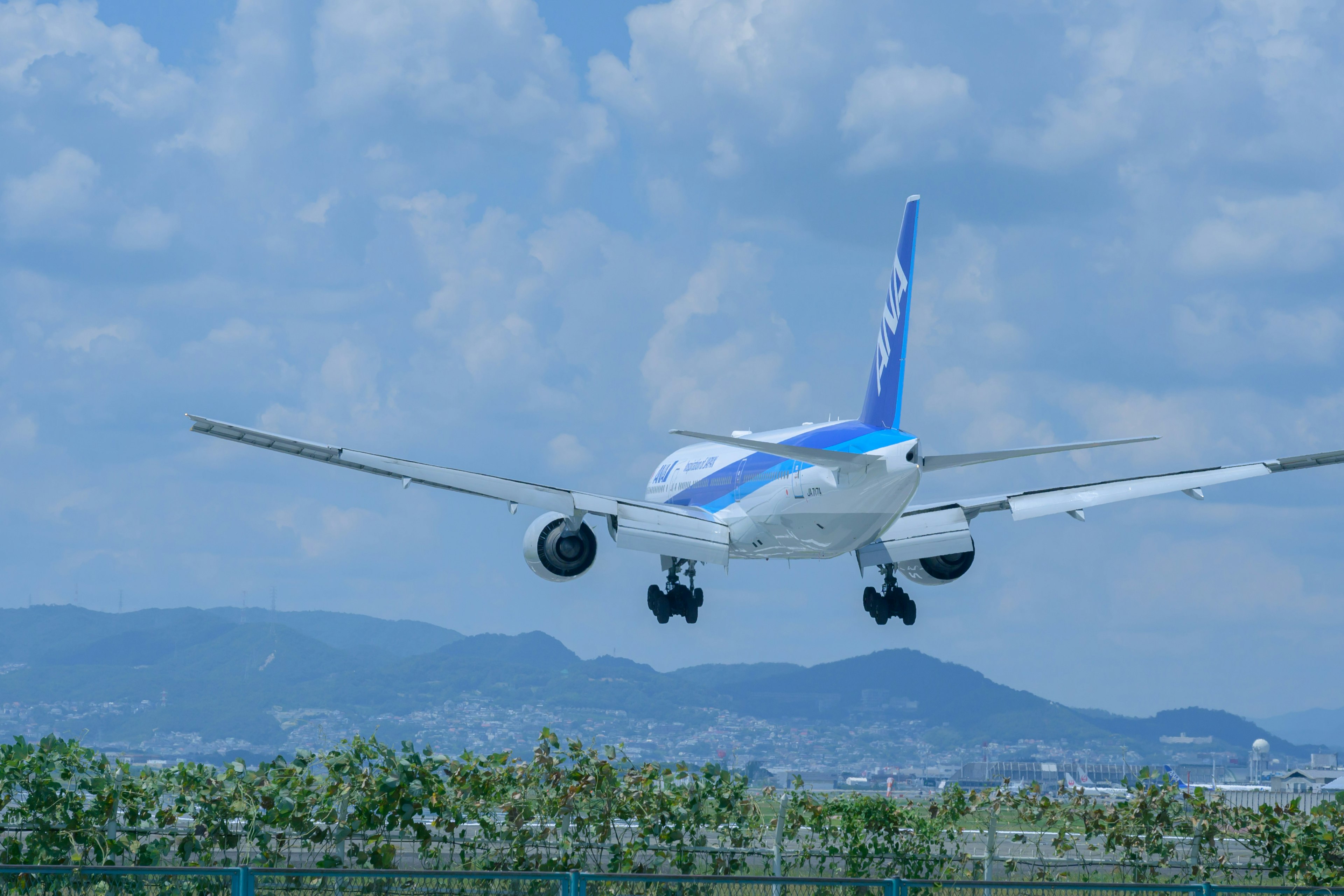 Pesawat penumpang mendarat di bawah langit biru