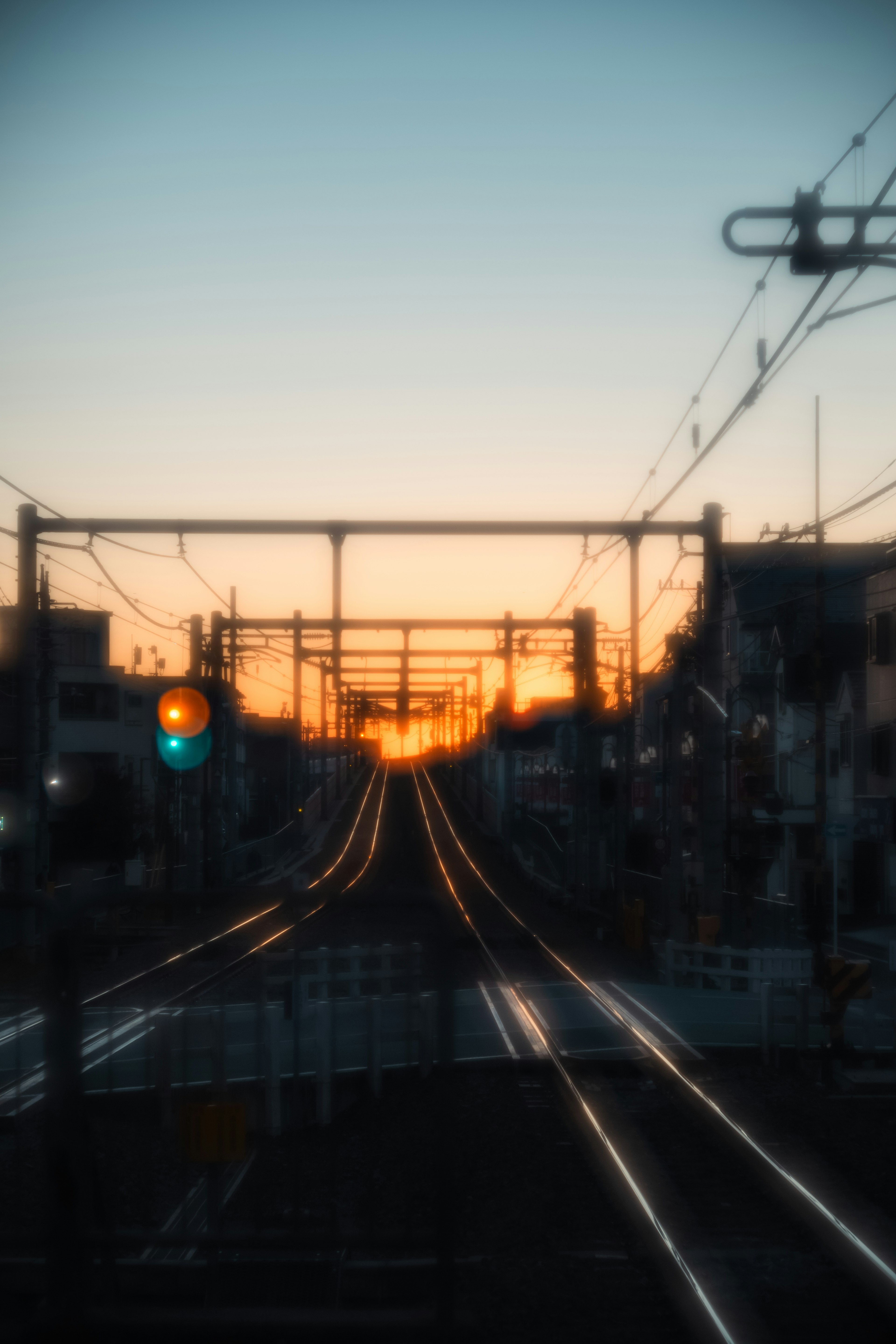 夕焼けの中を走る鉄道路線と信号機