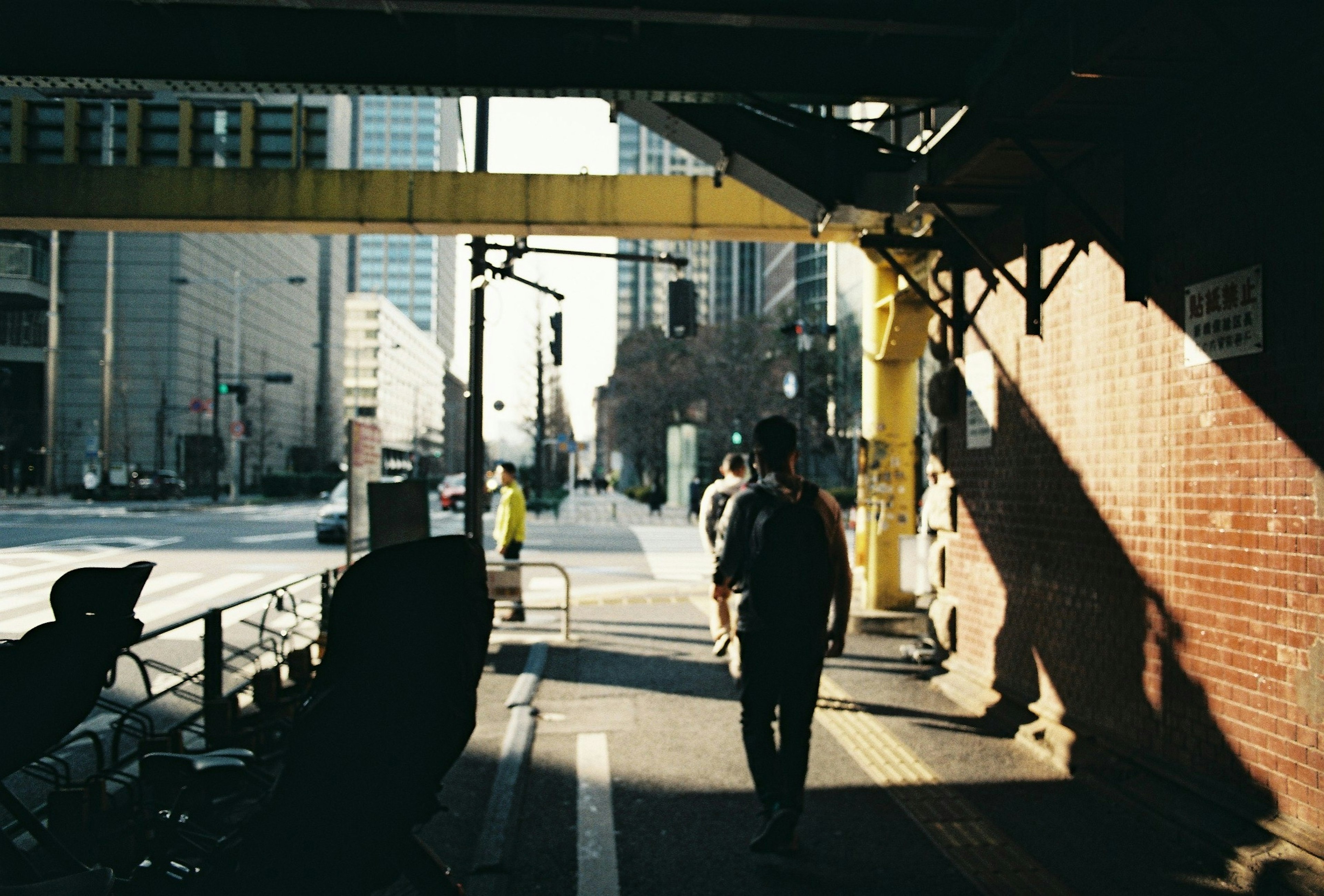 Scène urbaine avec une personne marchant sous un pont ferroviaire Lumière du soleil et ombres