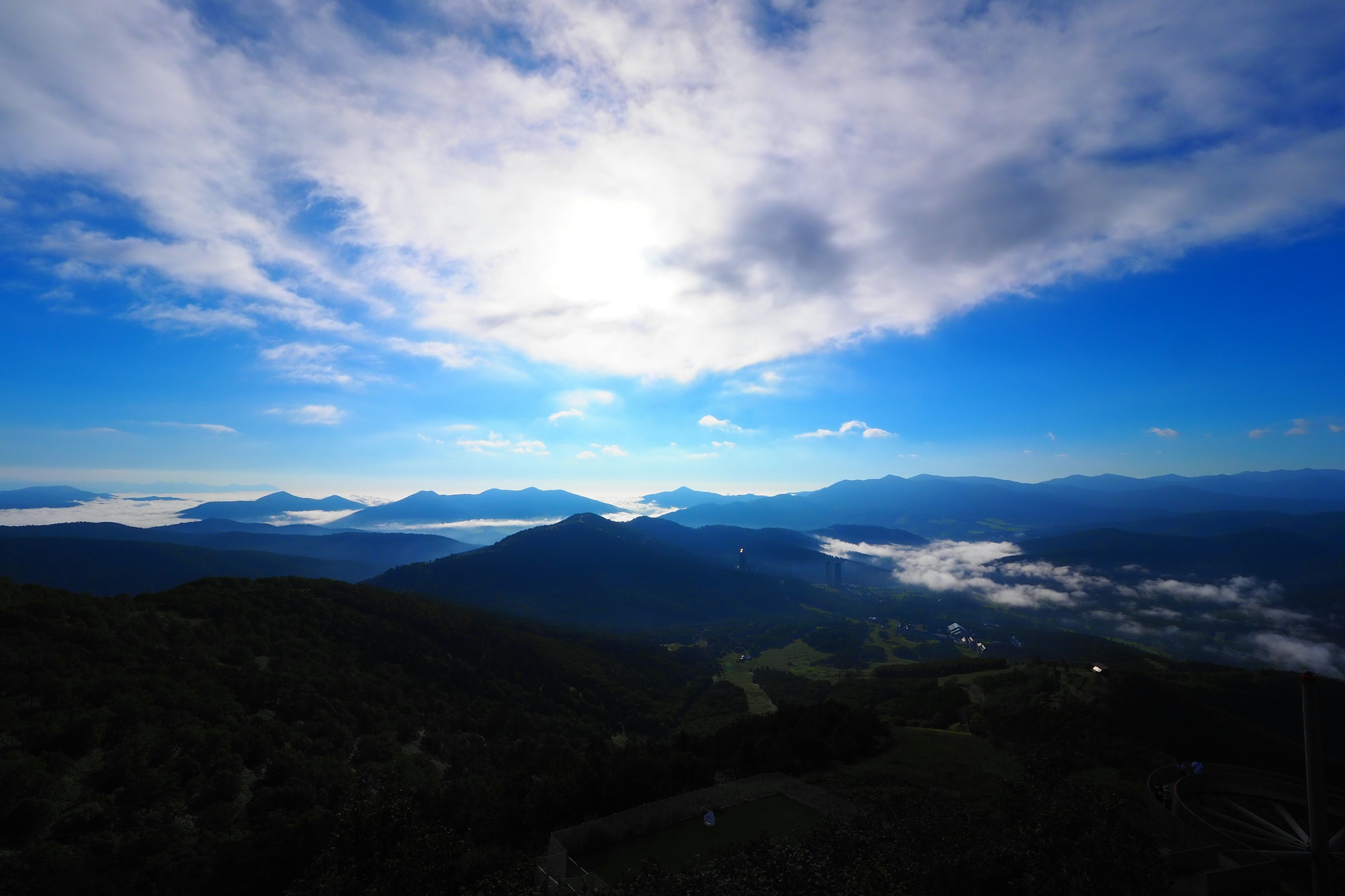 Pemandangan pegunungan di bawah langit biru dengan awan