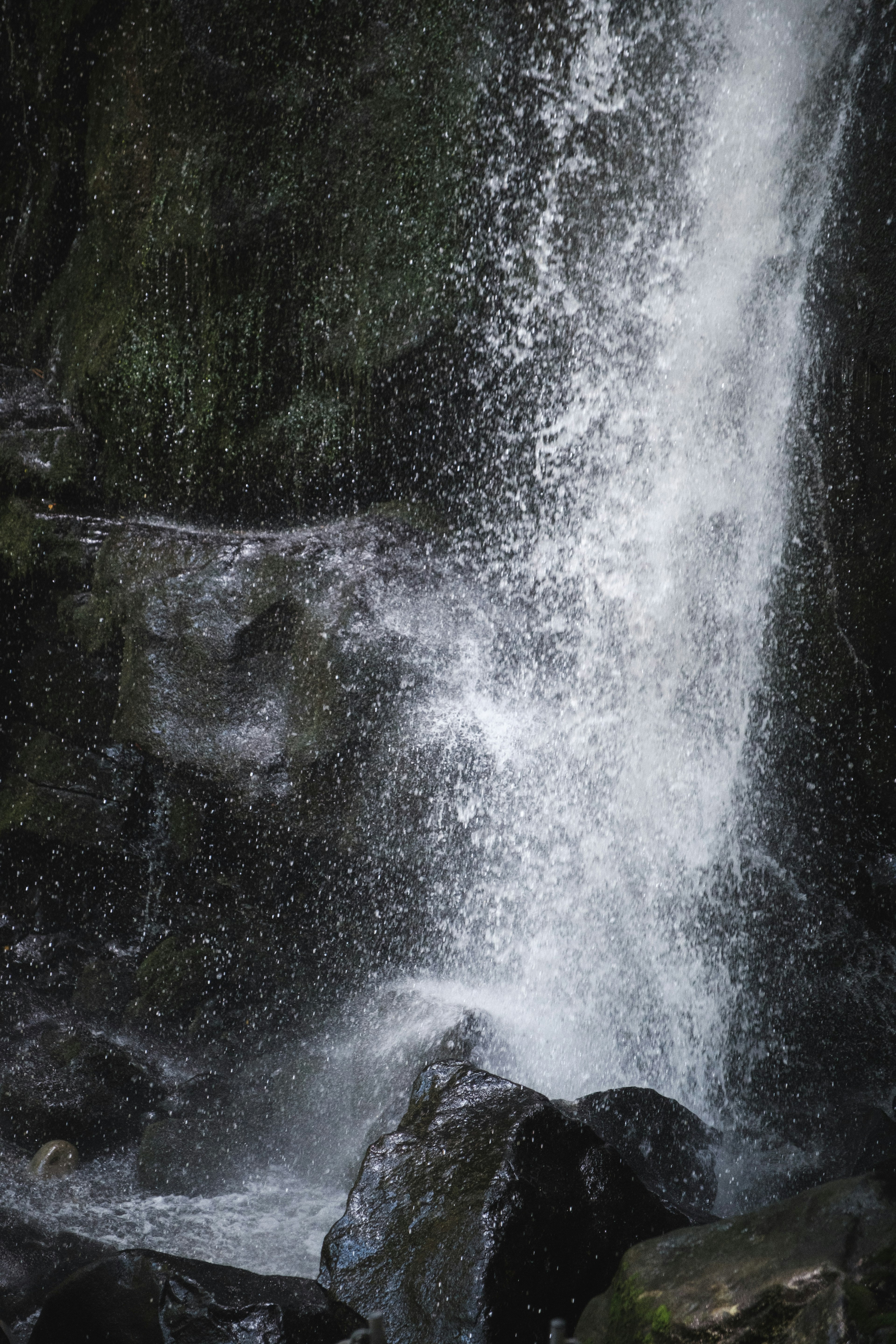 Paisaje natural con salpicaduras de cascada y rocas oscuras