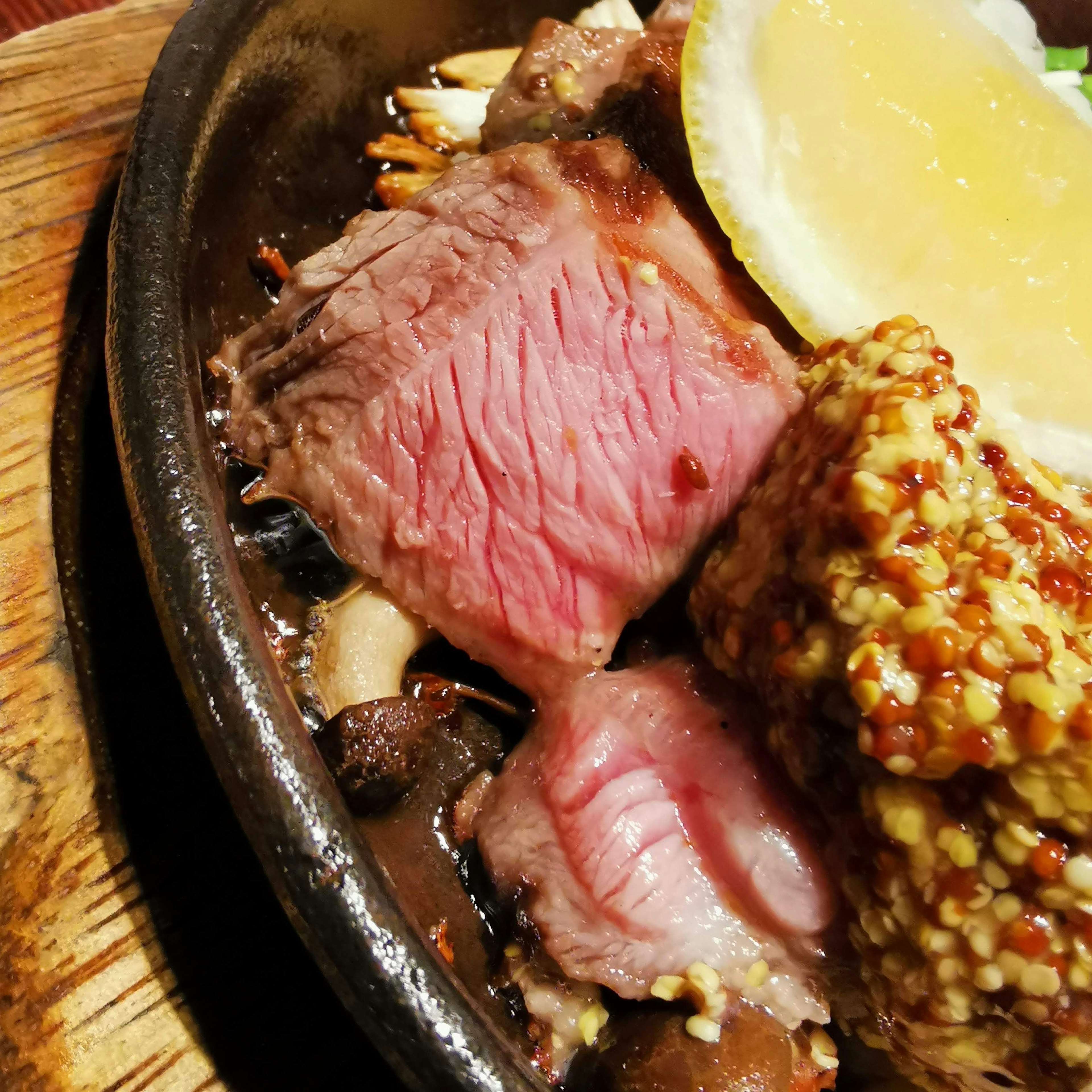 Steak juteux servi sur une plaque brûlante avec une tranche de citron