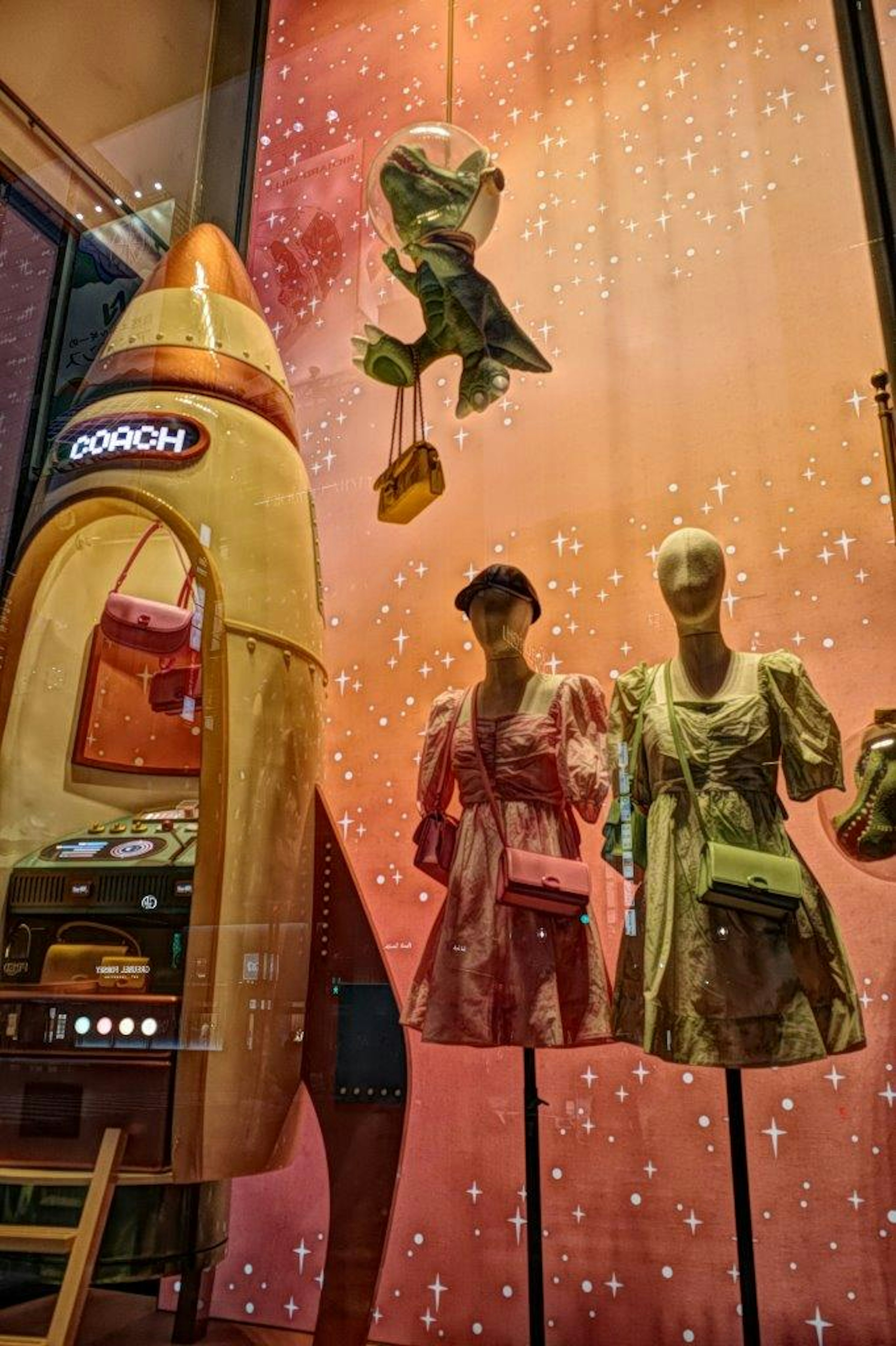 Fashion dresses displayed in a window with a rocket-shaped display