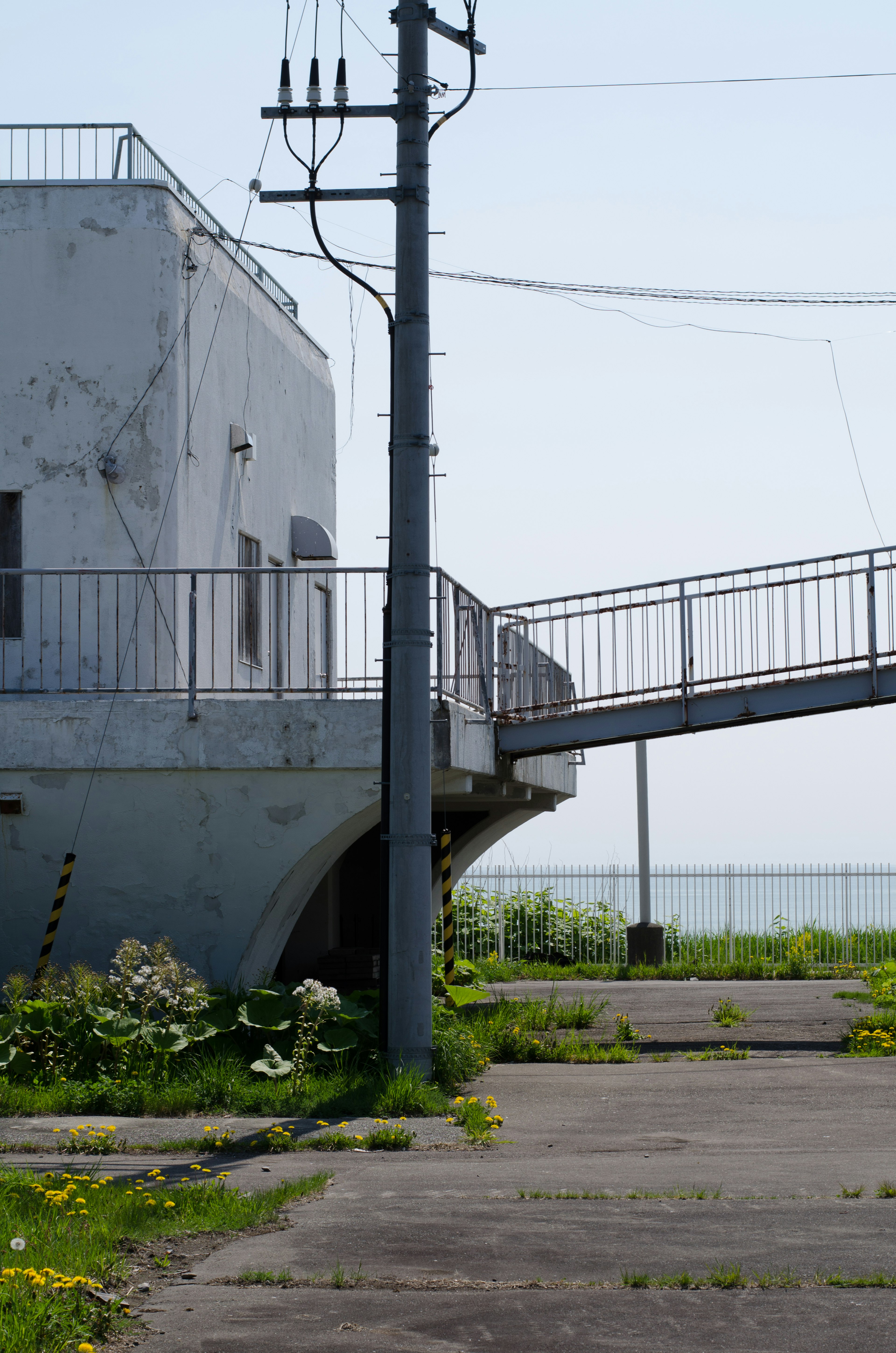 Bâtiment abandonné avec rampe et chemin envahi par la végétation