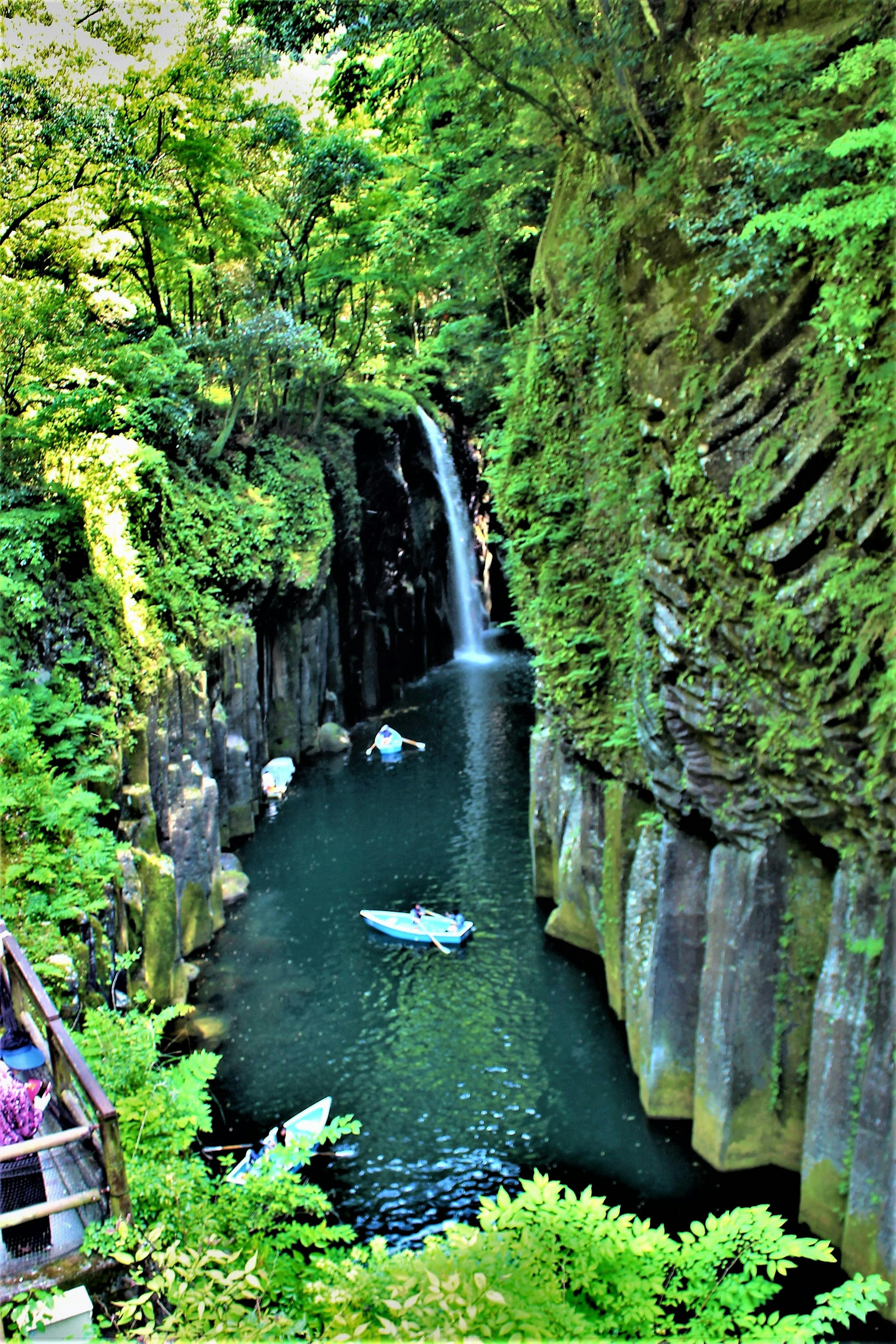 A serene valley scene featuring a waterfall surrounded by lush greenery