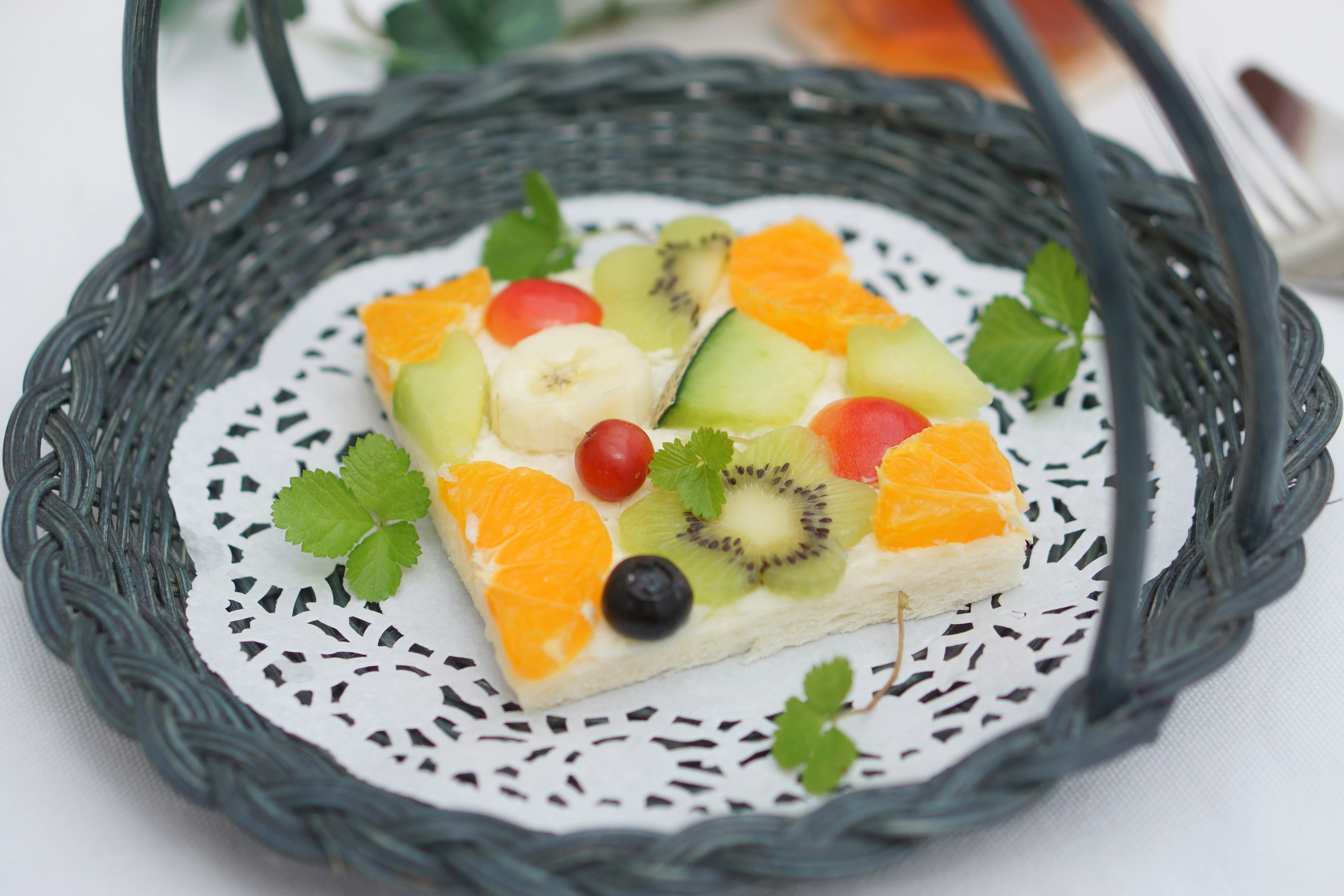 Dessert with assorted fruits and cream in a basket