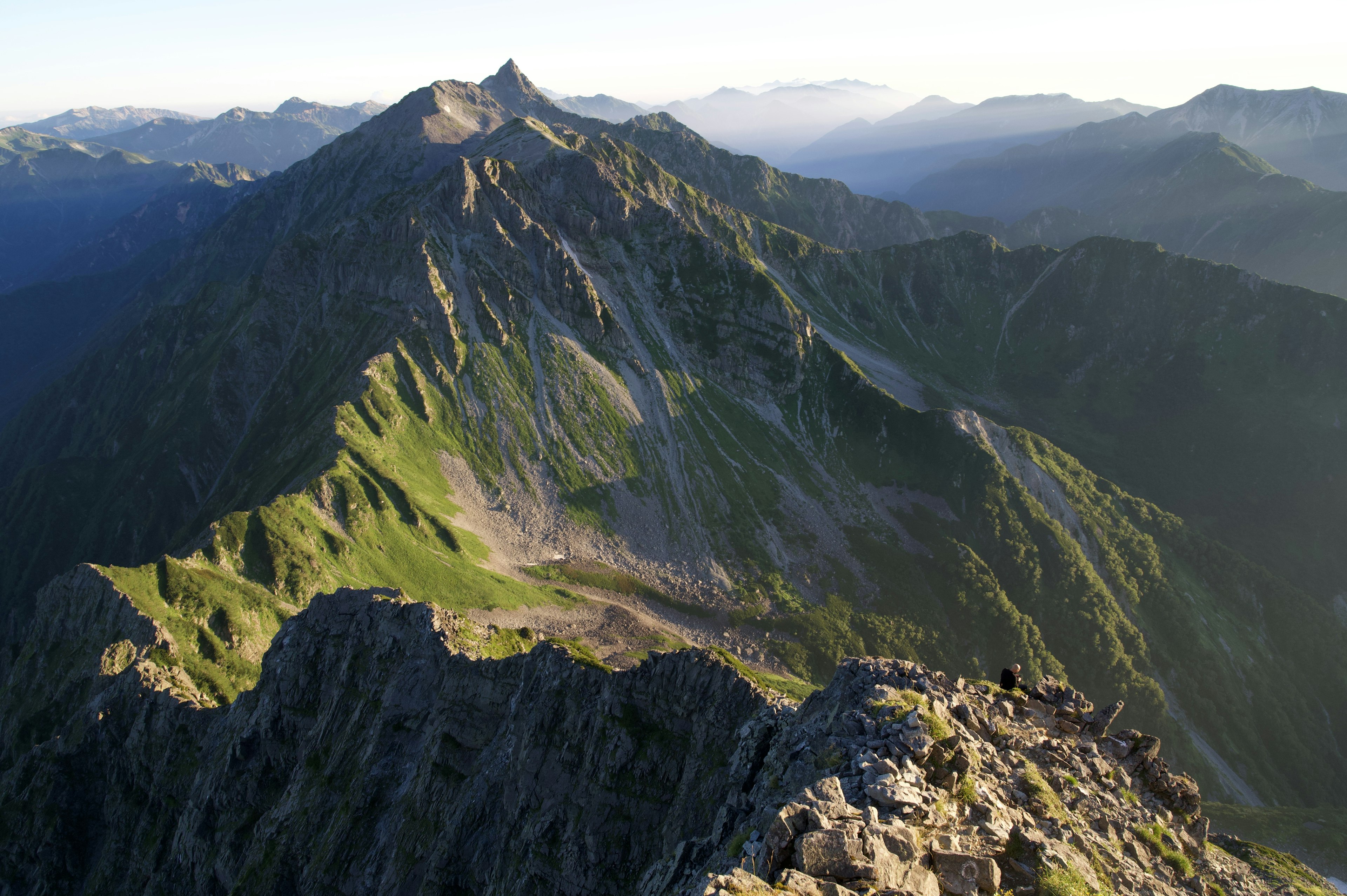 Berglandschaft mit üppigem Grün und felsigen Gipfeln