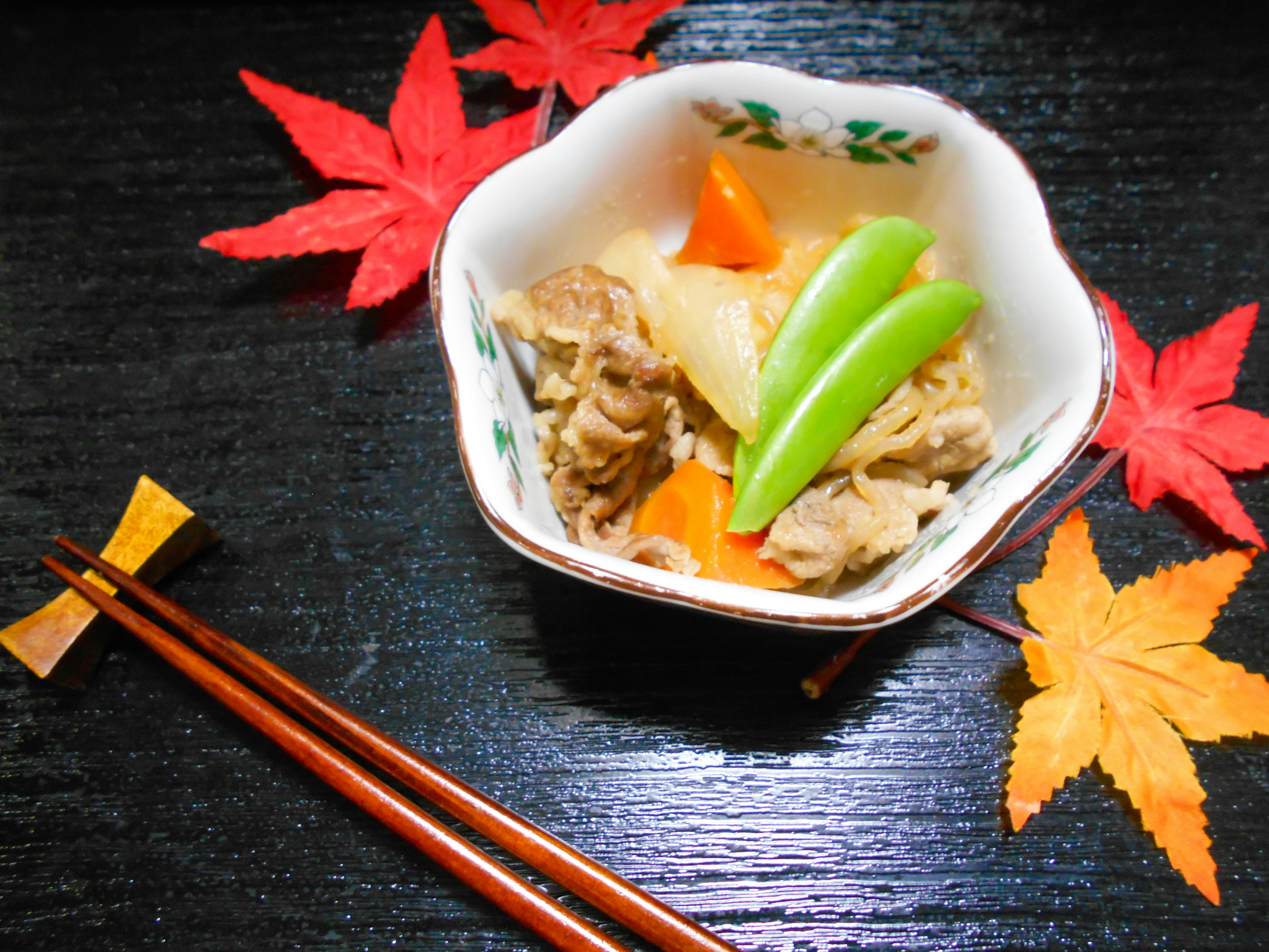 Sebuah mangkuk masakan Jepang disajikan dengan daun musim gugur