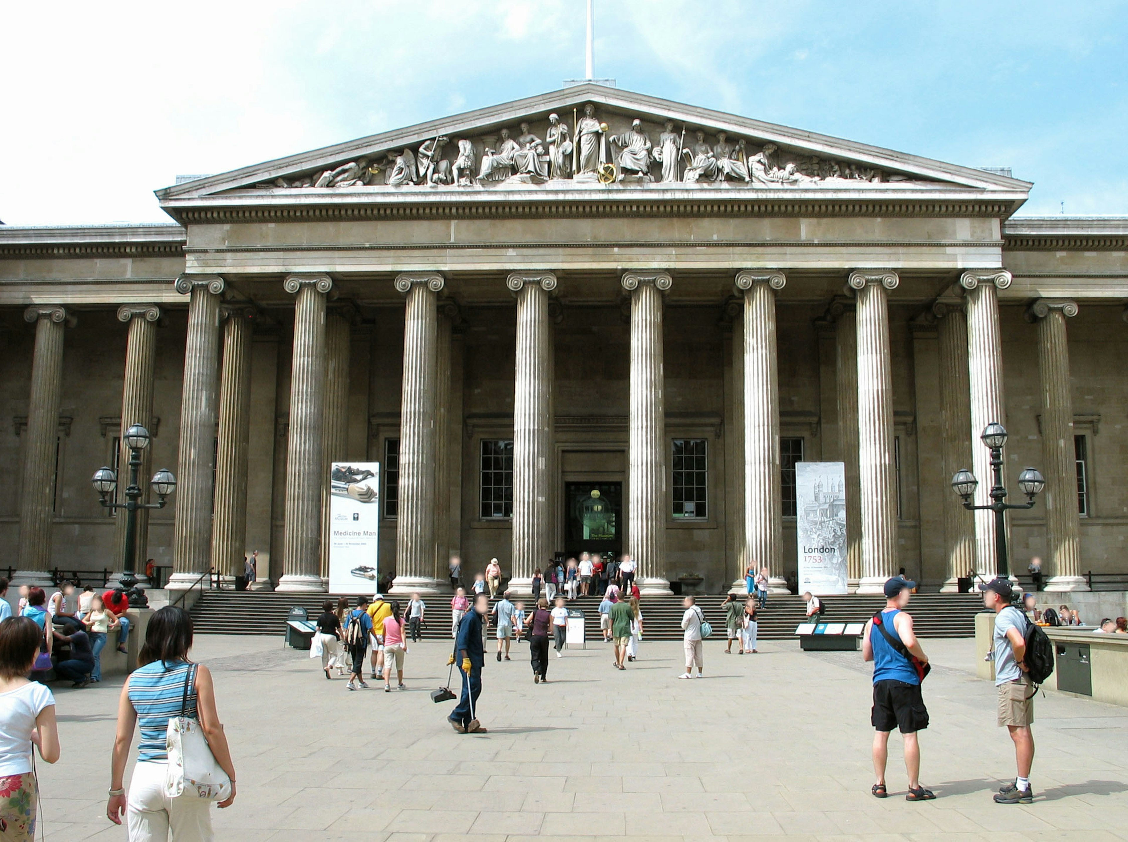 The grand facade of the British Museum with people walking around