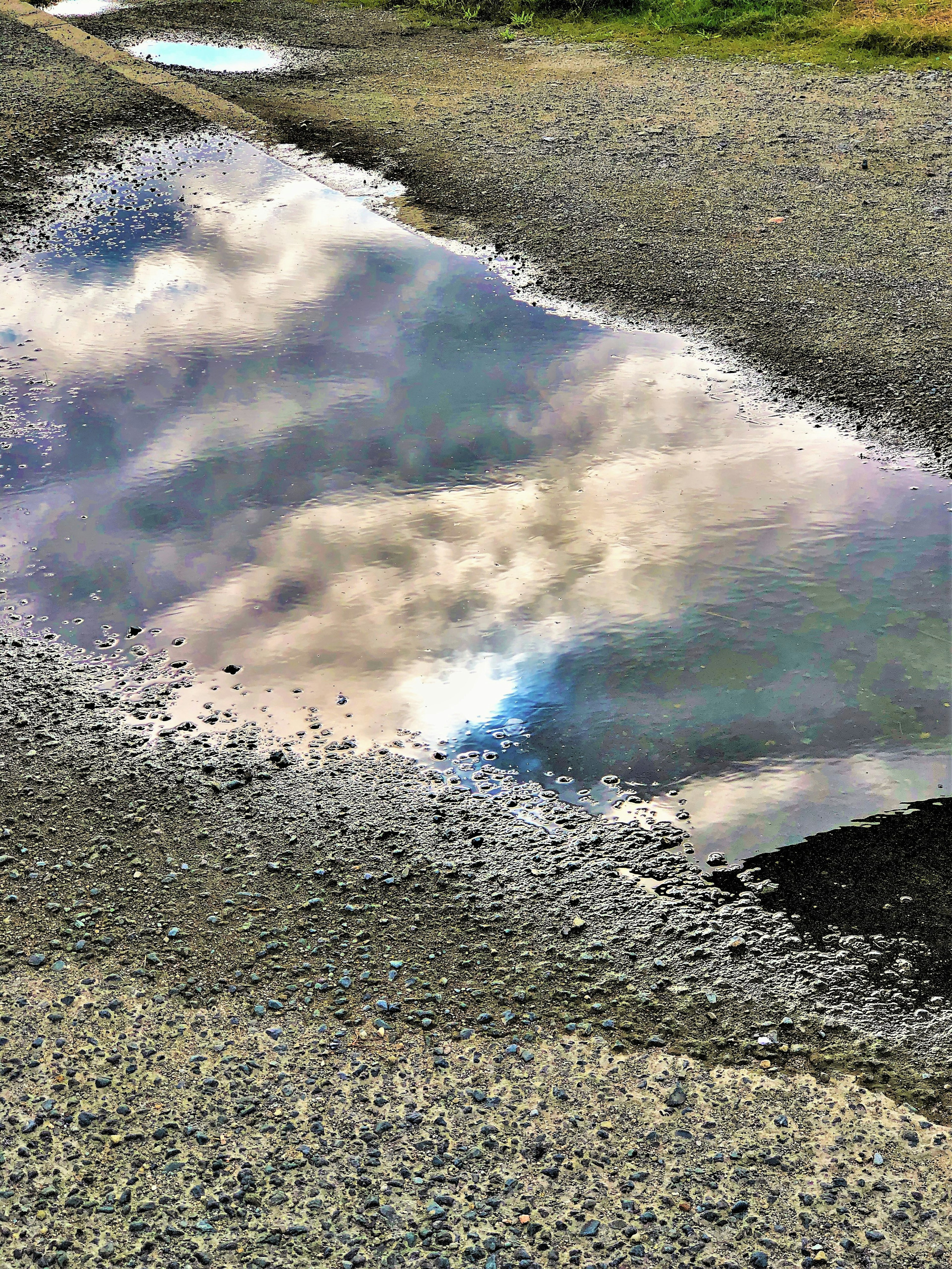 Beautiful reflection of clouds and colors in a puddle