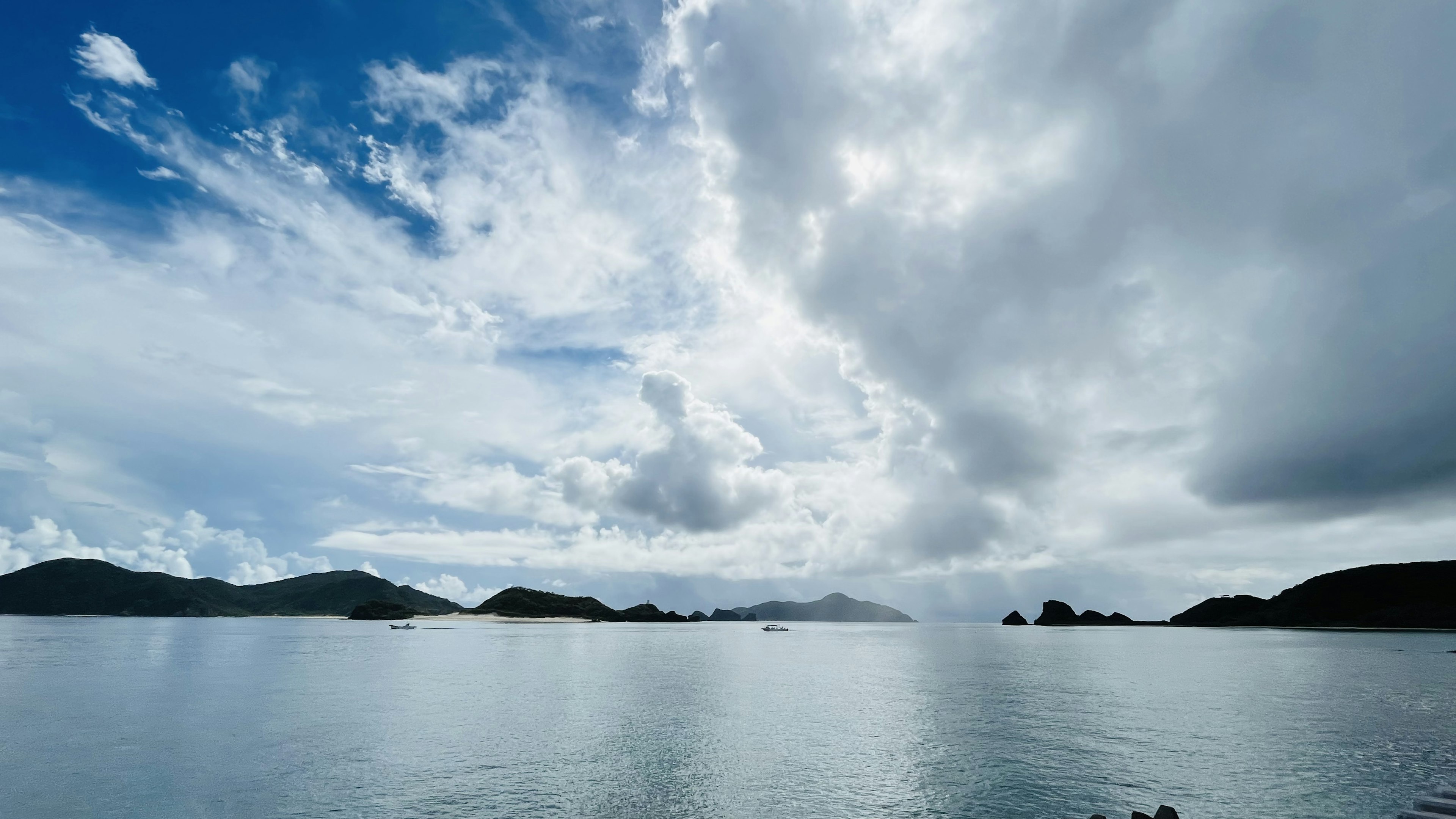 青空と雲が広がる海の風景で静かな水面が映る