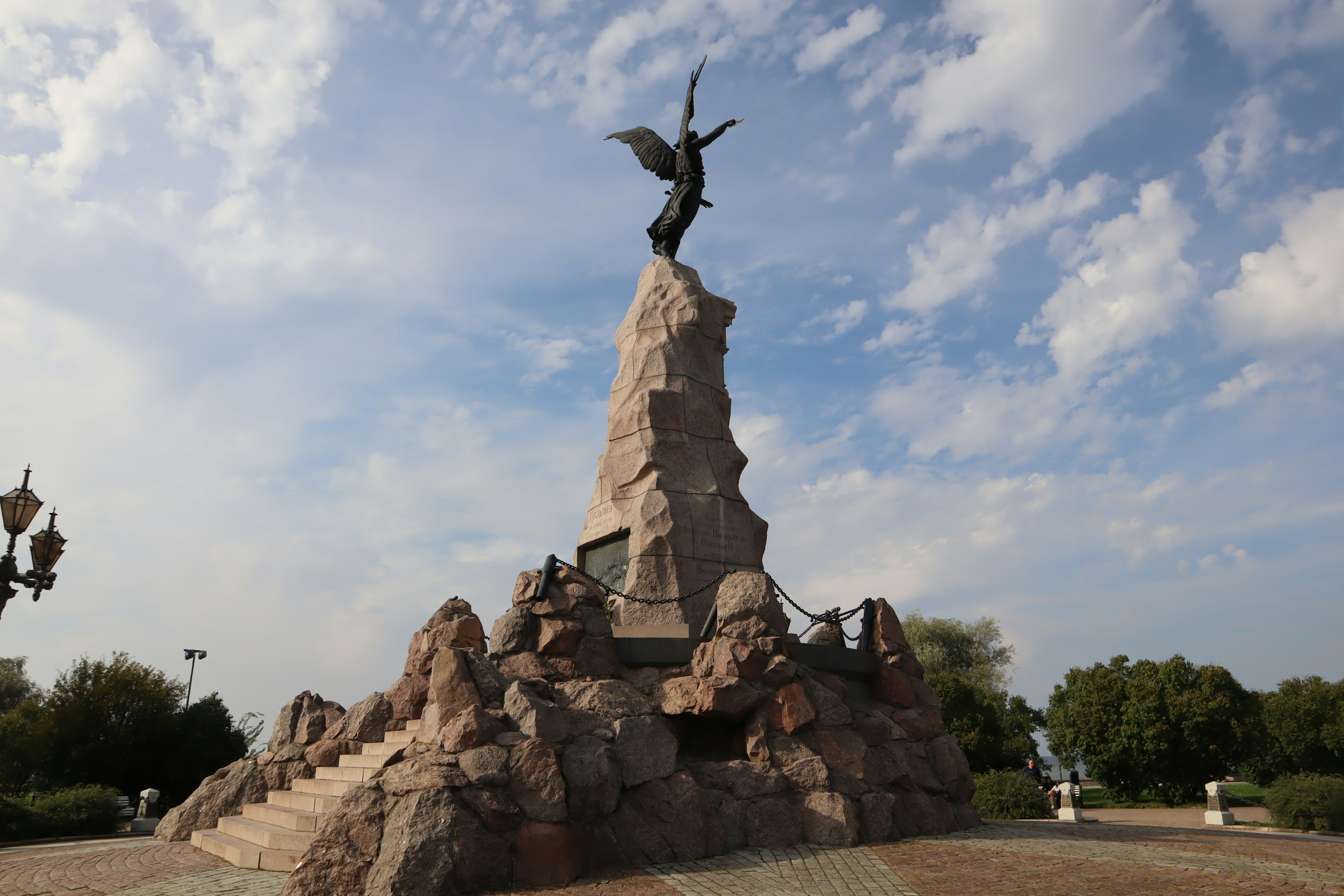 Estatua de un ángel sobre una formación rocosa en un parque