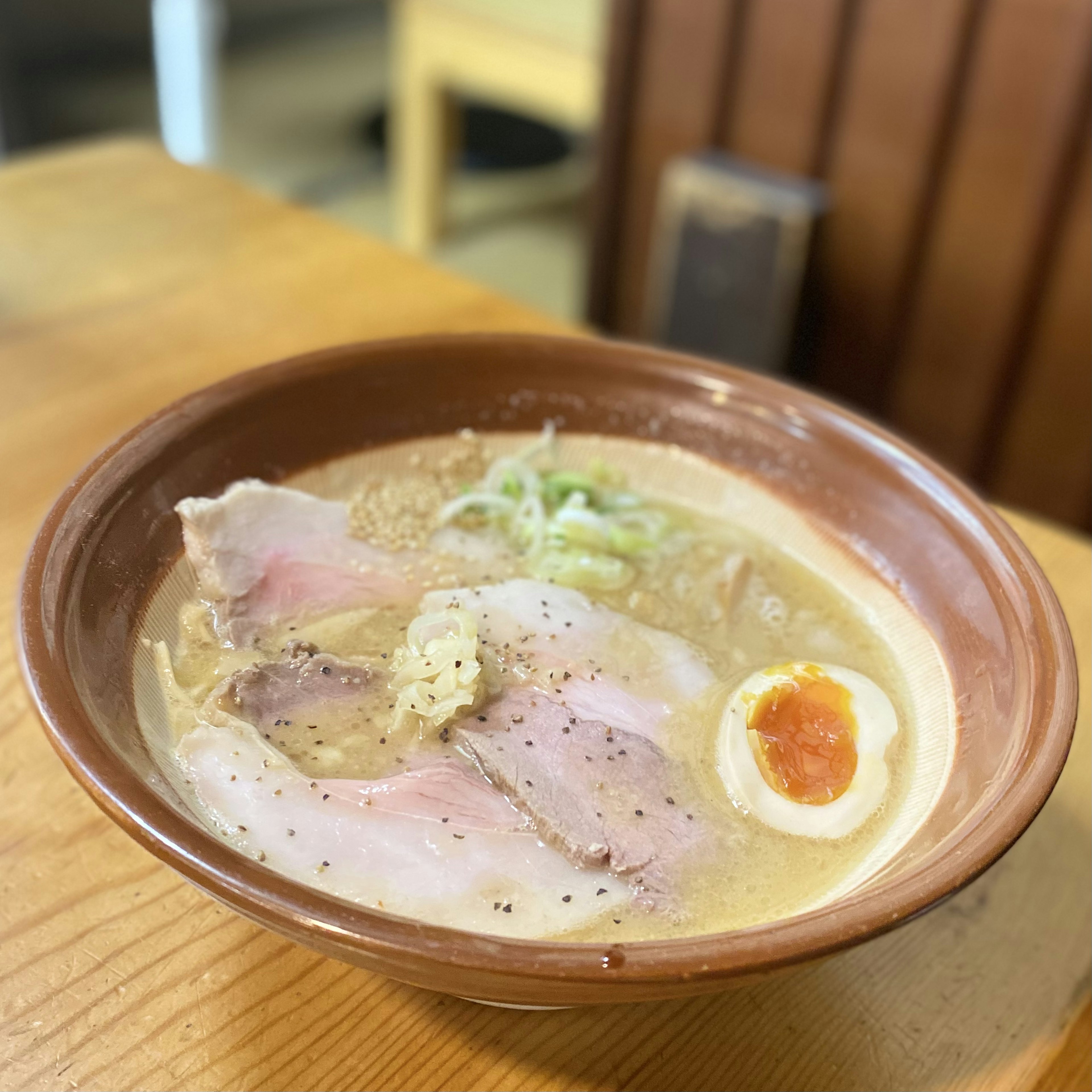 Una ciotola di ramen con fette di chashu e un uovo sodo