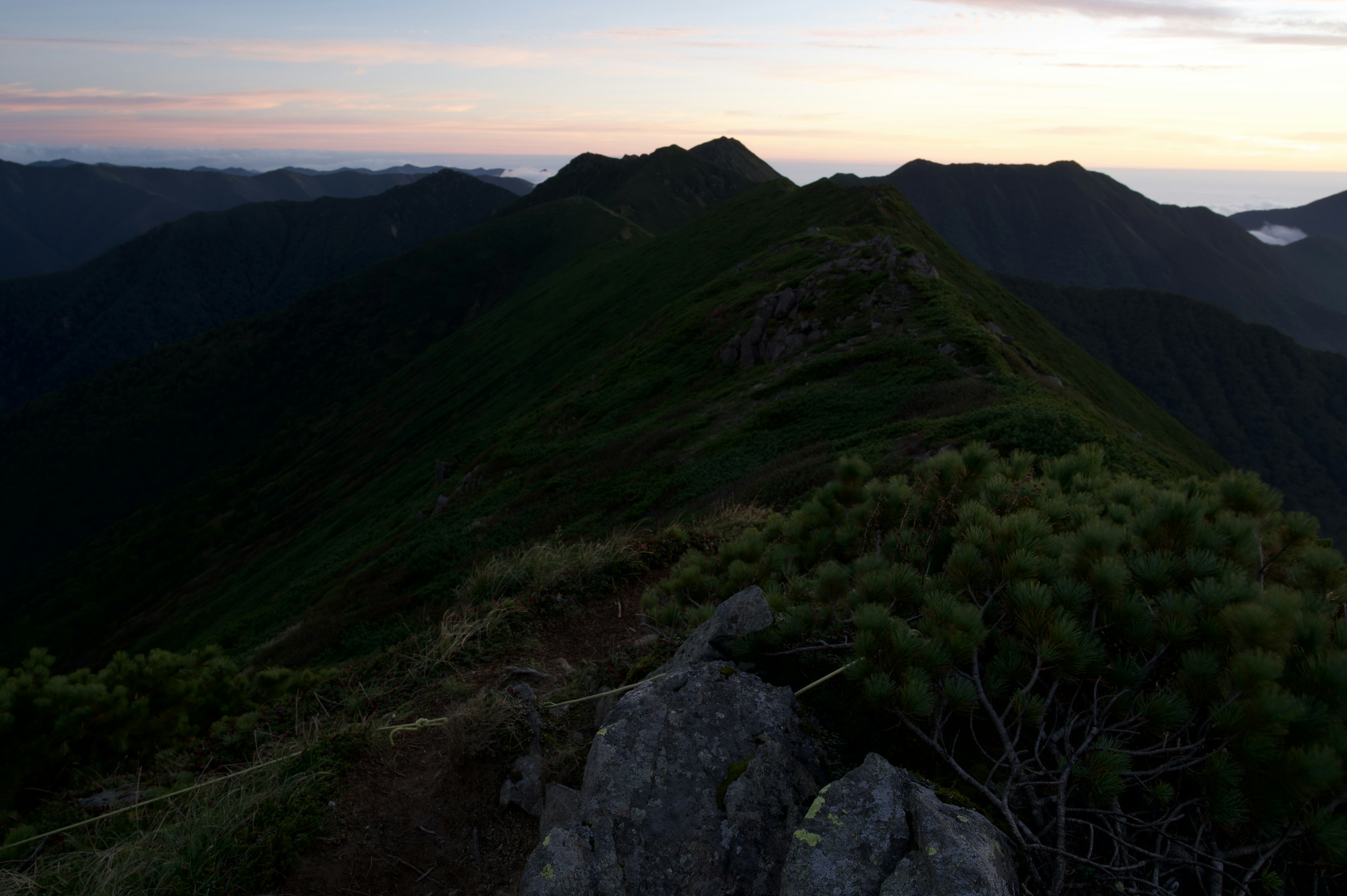 山の稜線と夕暮れの空が広がる風景