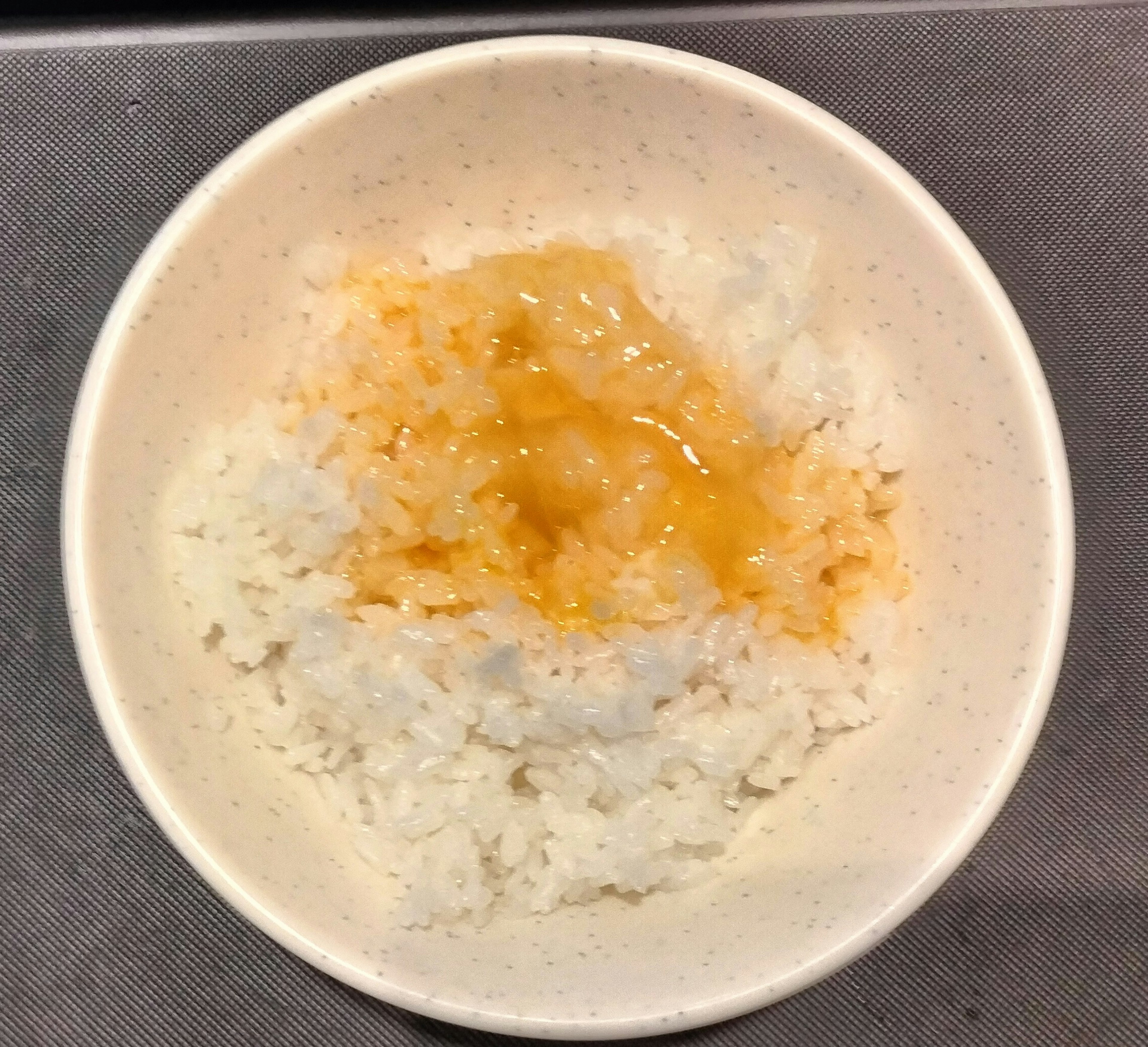 A bowl of white rice topped with a sweet sauce