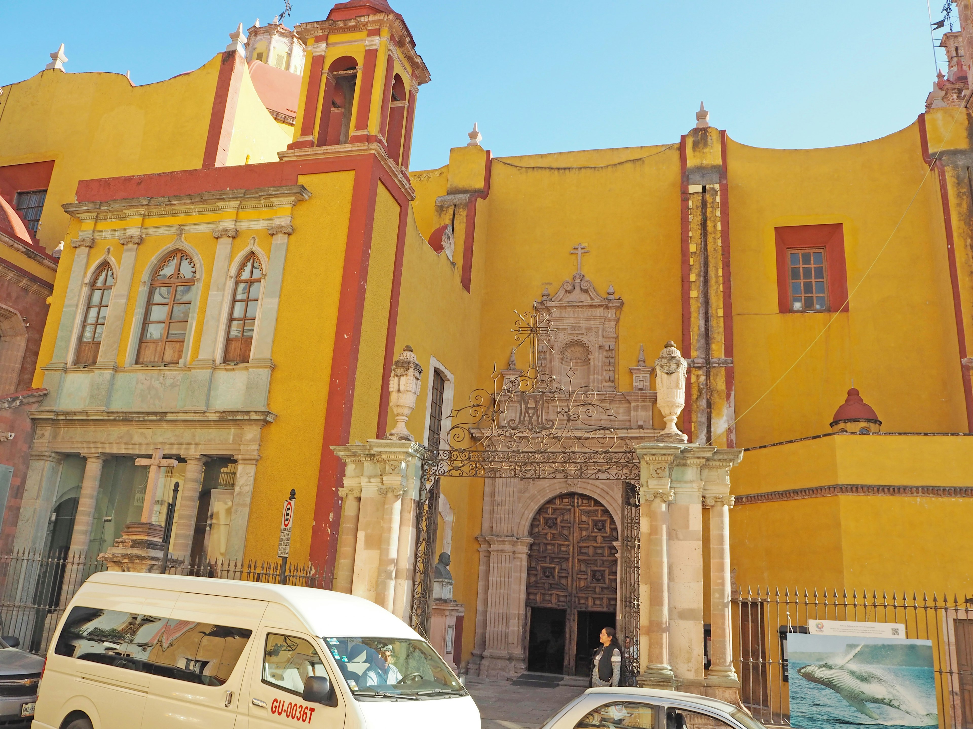 Esterno di chiesa gialla vivace con ingresso ad arco ornato