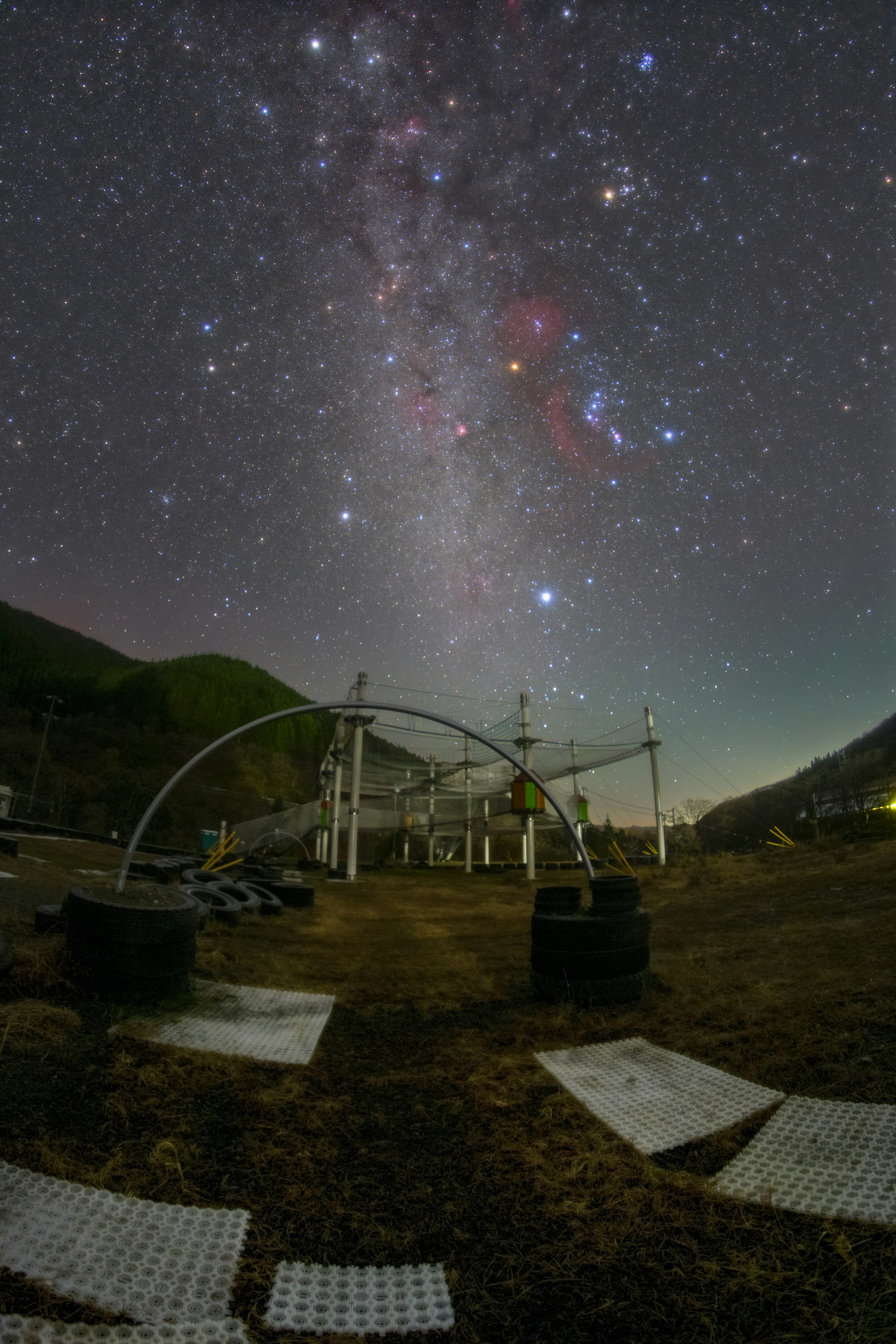 Paesaggio con montagne e attrezzature di osservazione astronomica sotto un cielo stellato