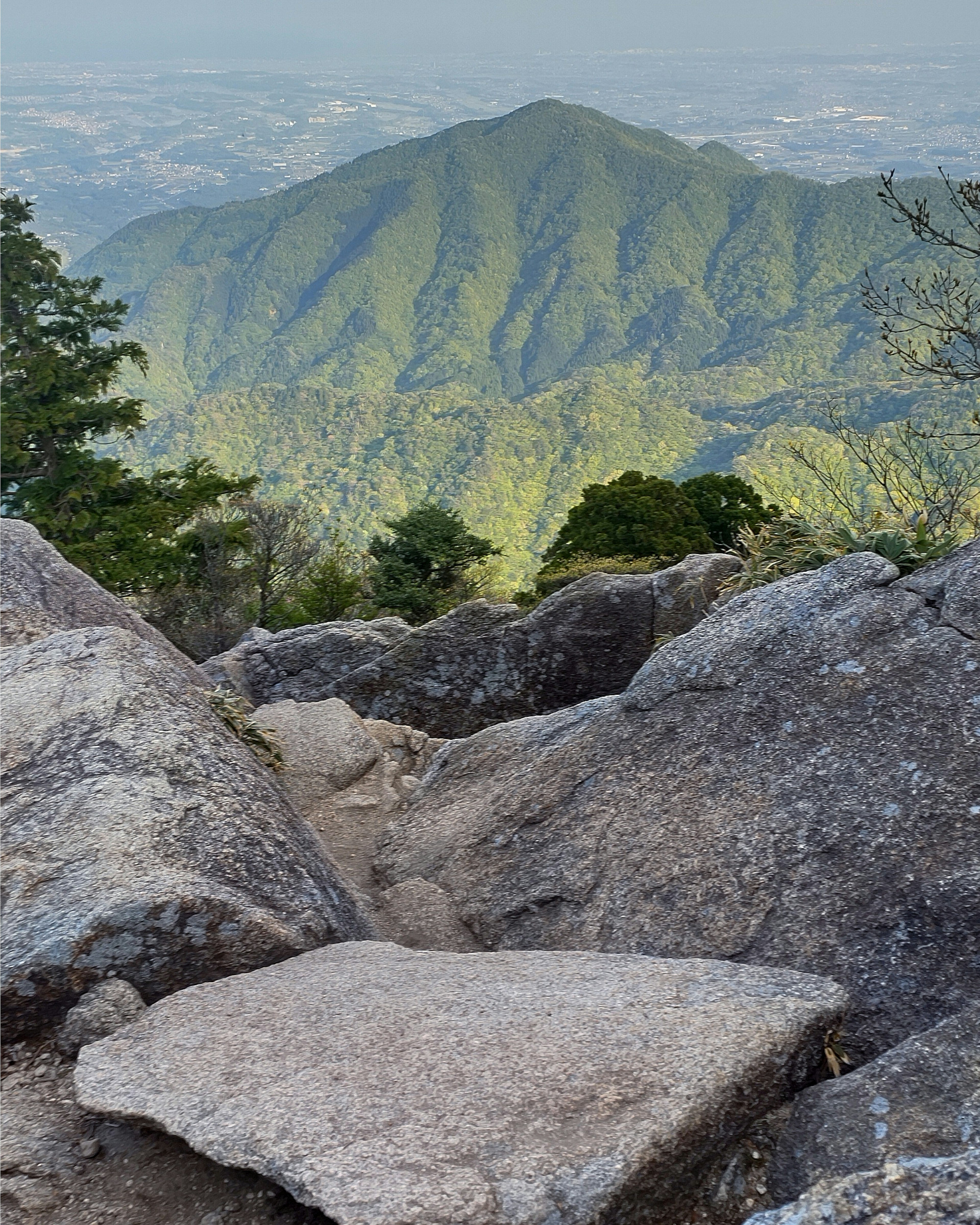 Vista escénica desde la cima de una montaña con colinas verdes y terreno rocoso