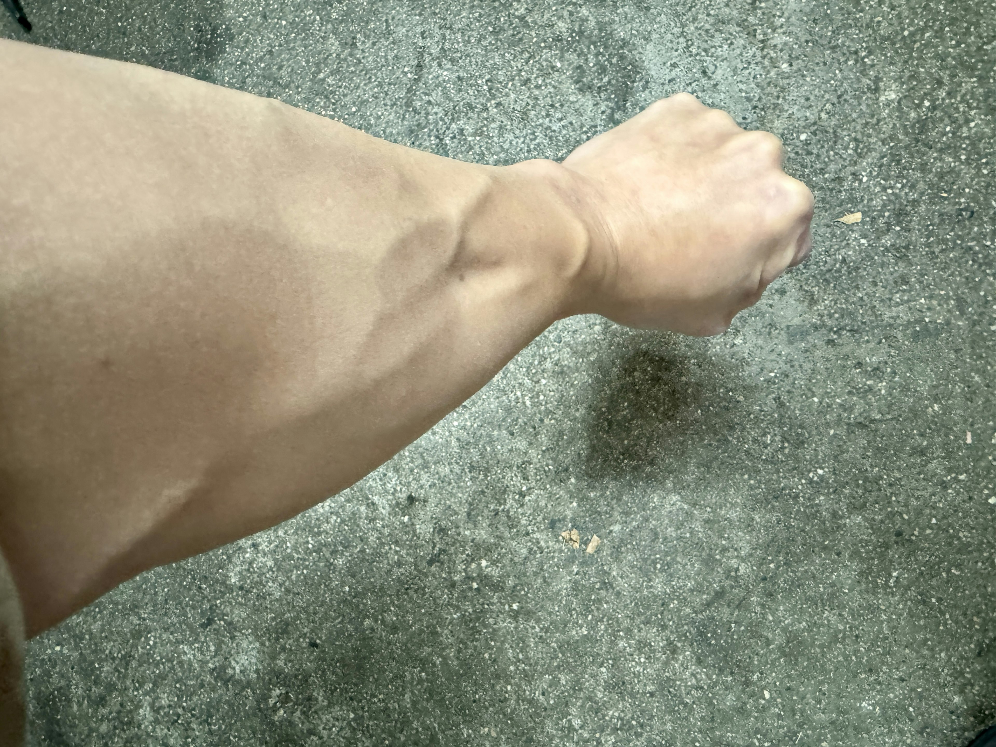 Close-up of a muscular arm with visible veins and clenched fist