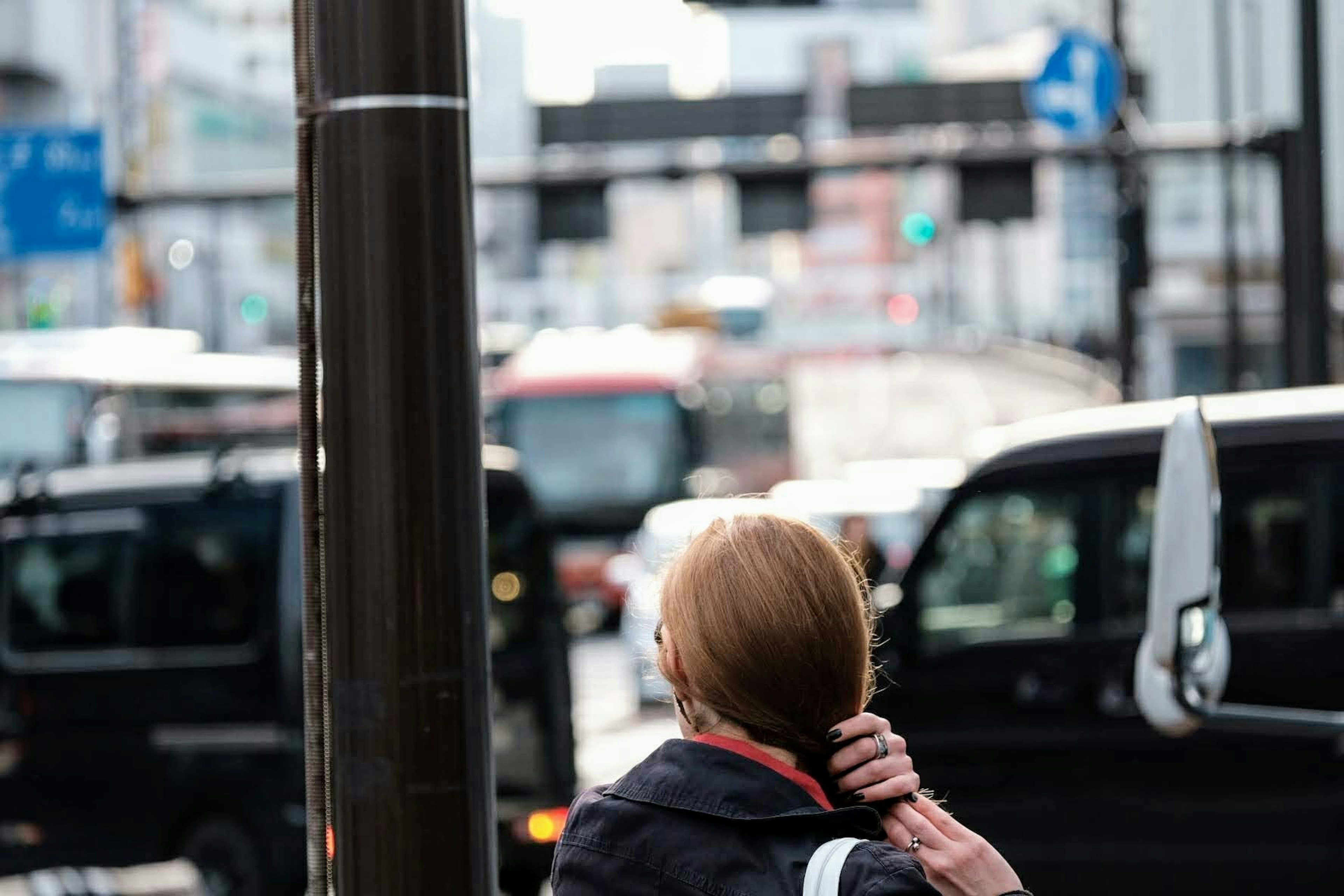 Una mujer esperando en un semáforo en un entorno urbano concurrido