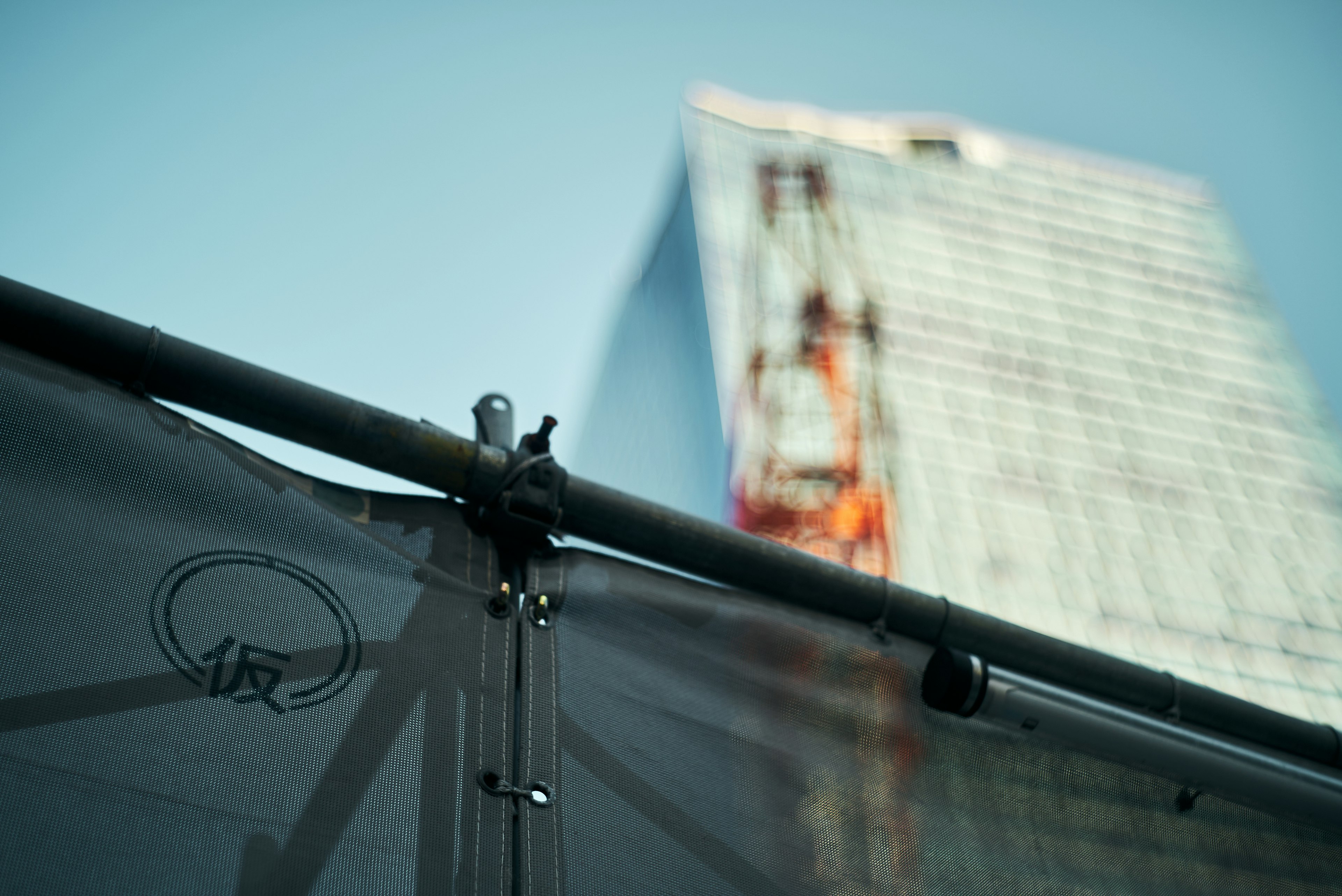 Close-up of a construction site with a blurred skyscraper in the background