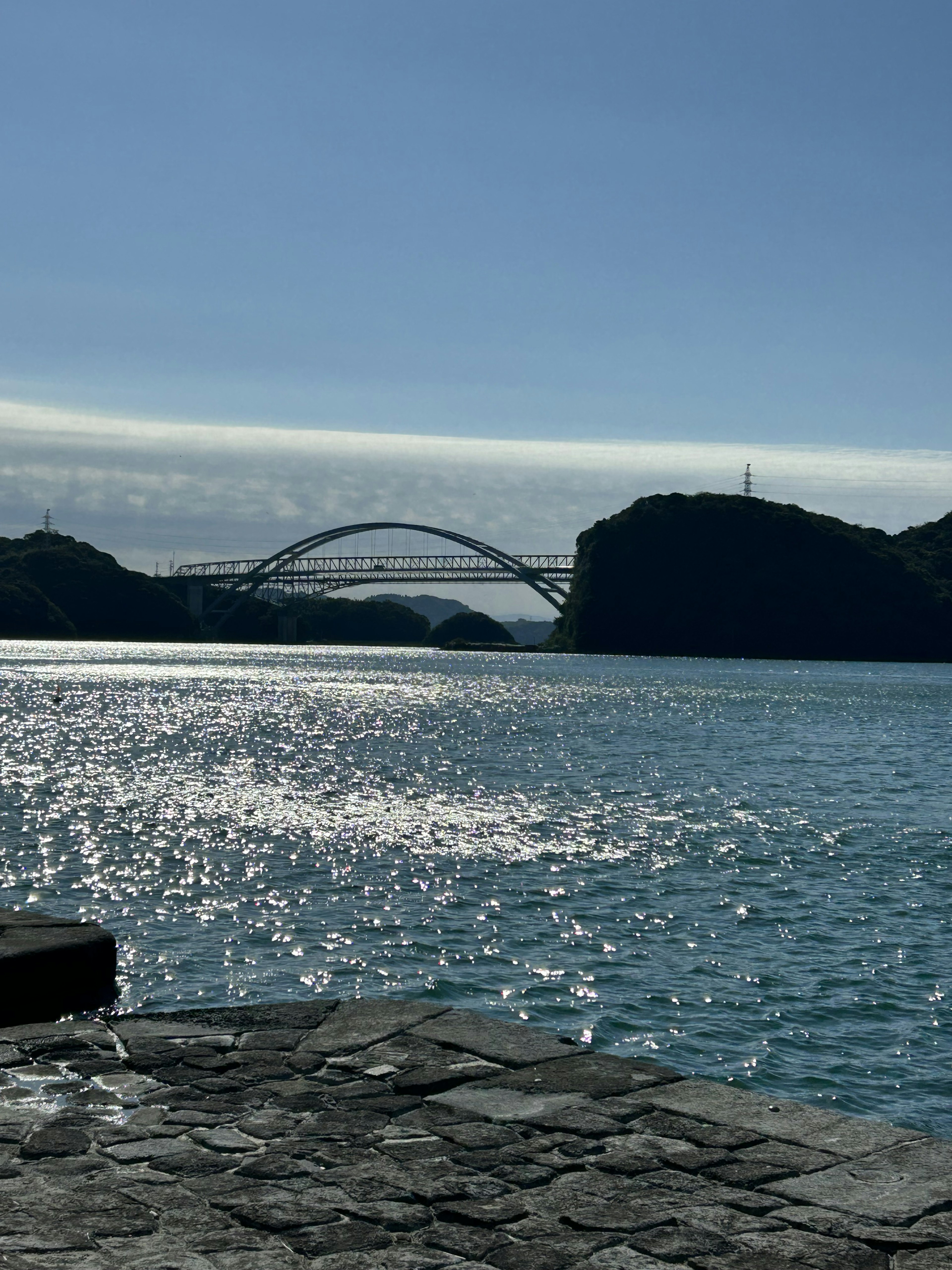 Vista escénica del agua azul con un puente al fondo