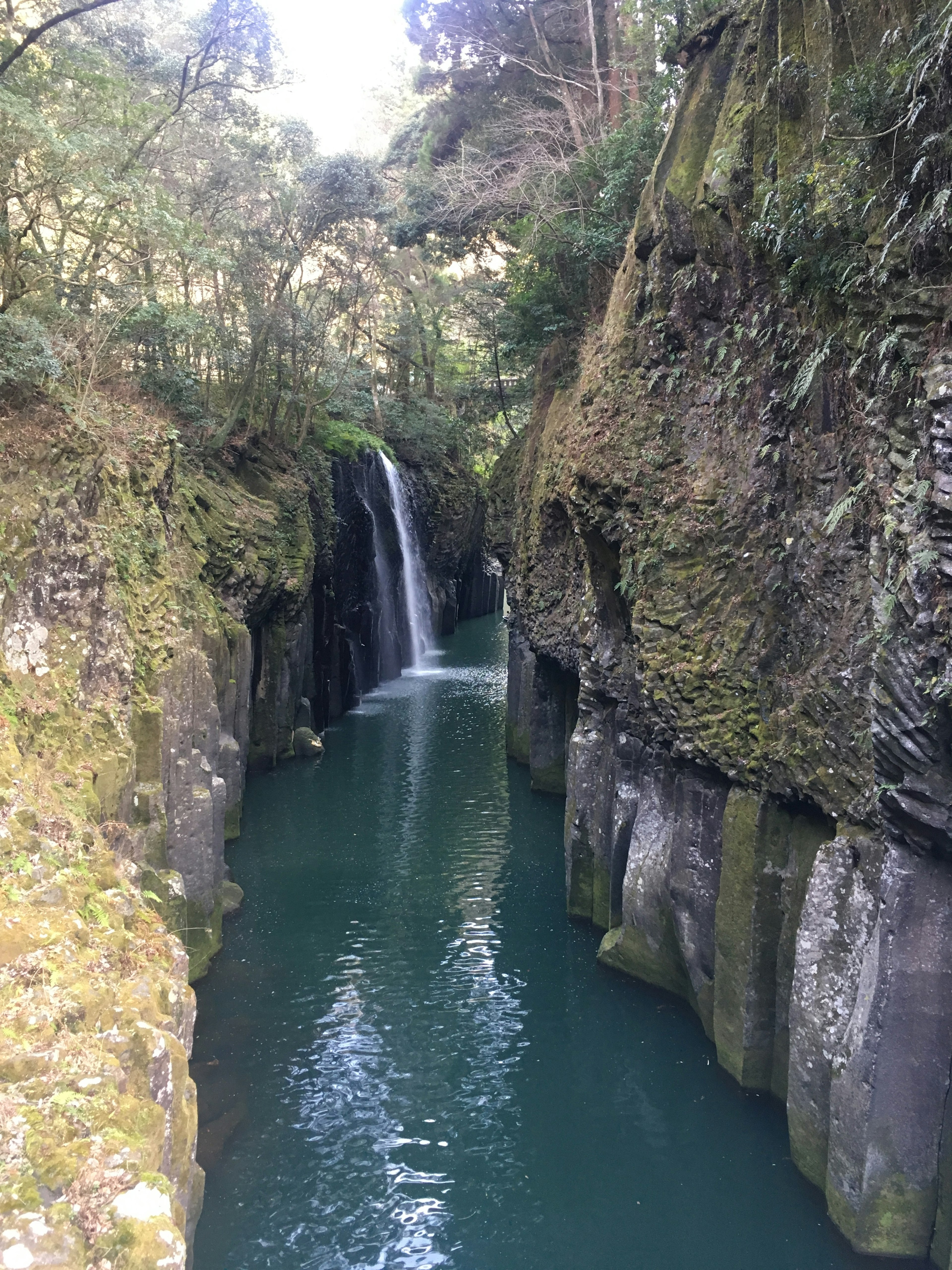 Scenic view of a deep canyon with flowing water and a waterfall