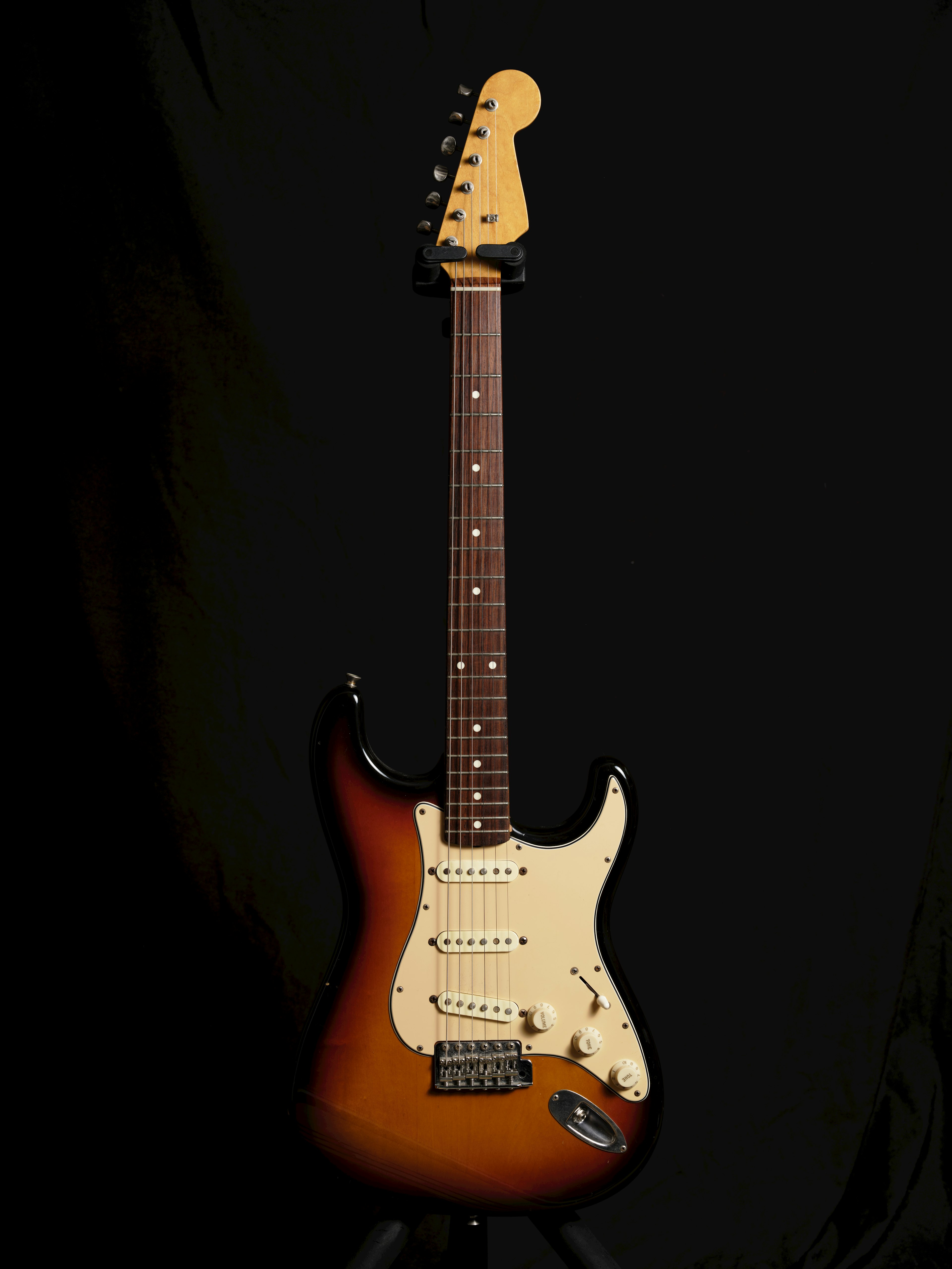 Sunburst electric guitar set against a black background