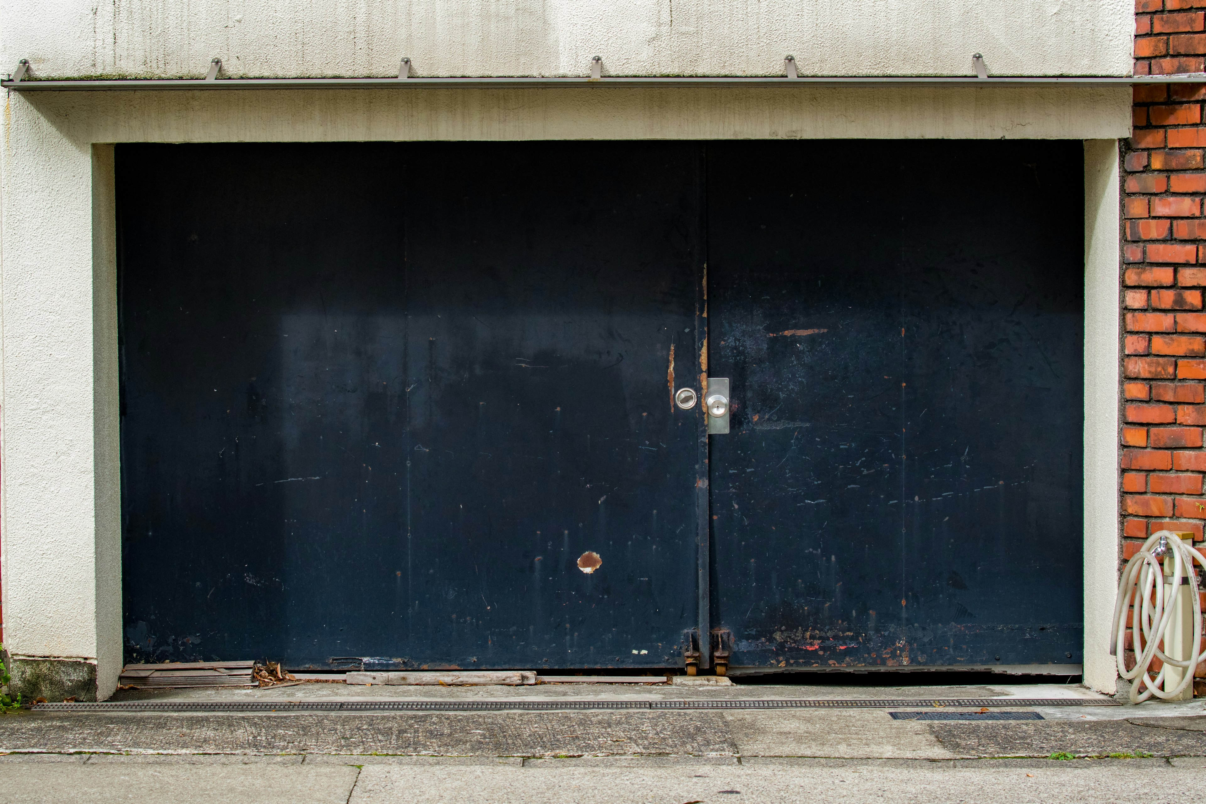 Blue garage door with weathered texture and surrounding wall