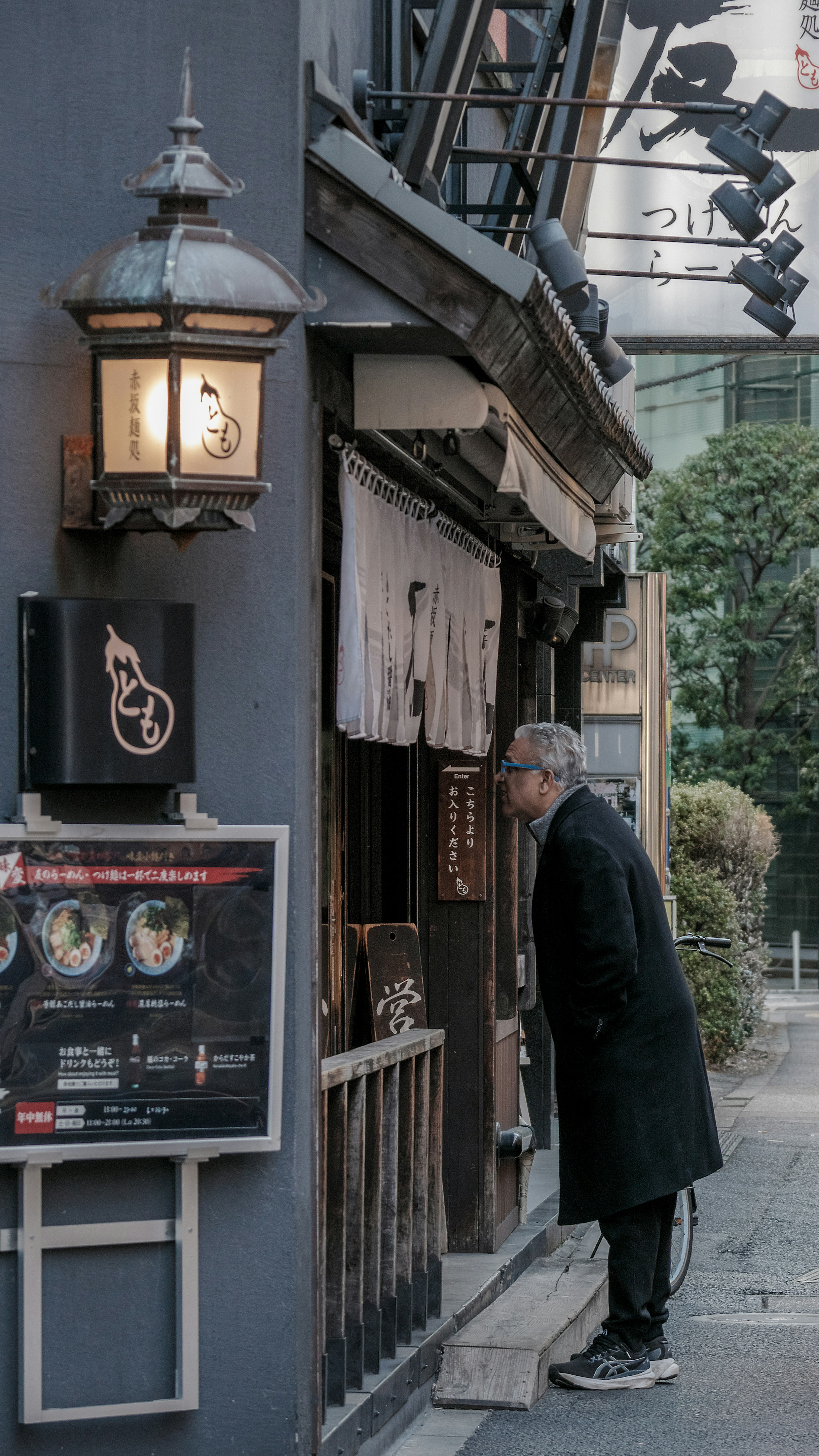 Un hombre asomándose a la entrada de un restaurante