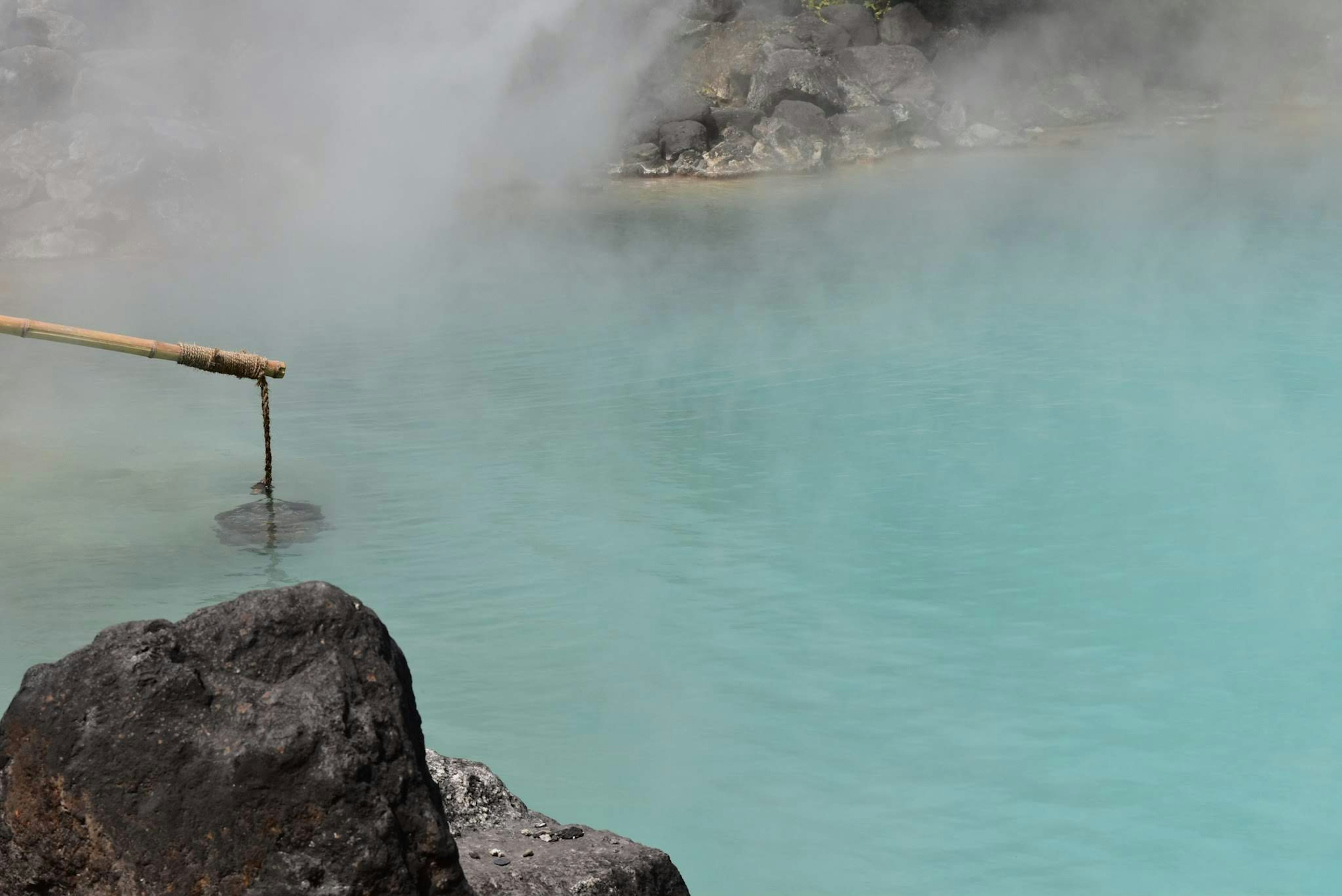 Pemandangan alam dengan kolam air panas biru dan uap