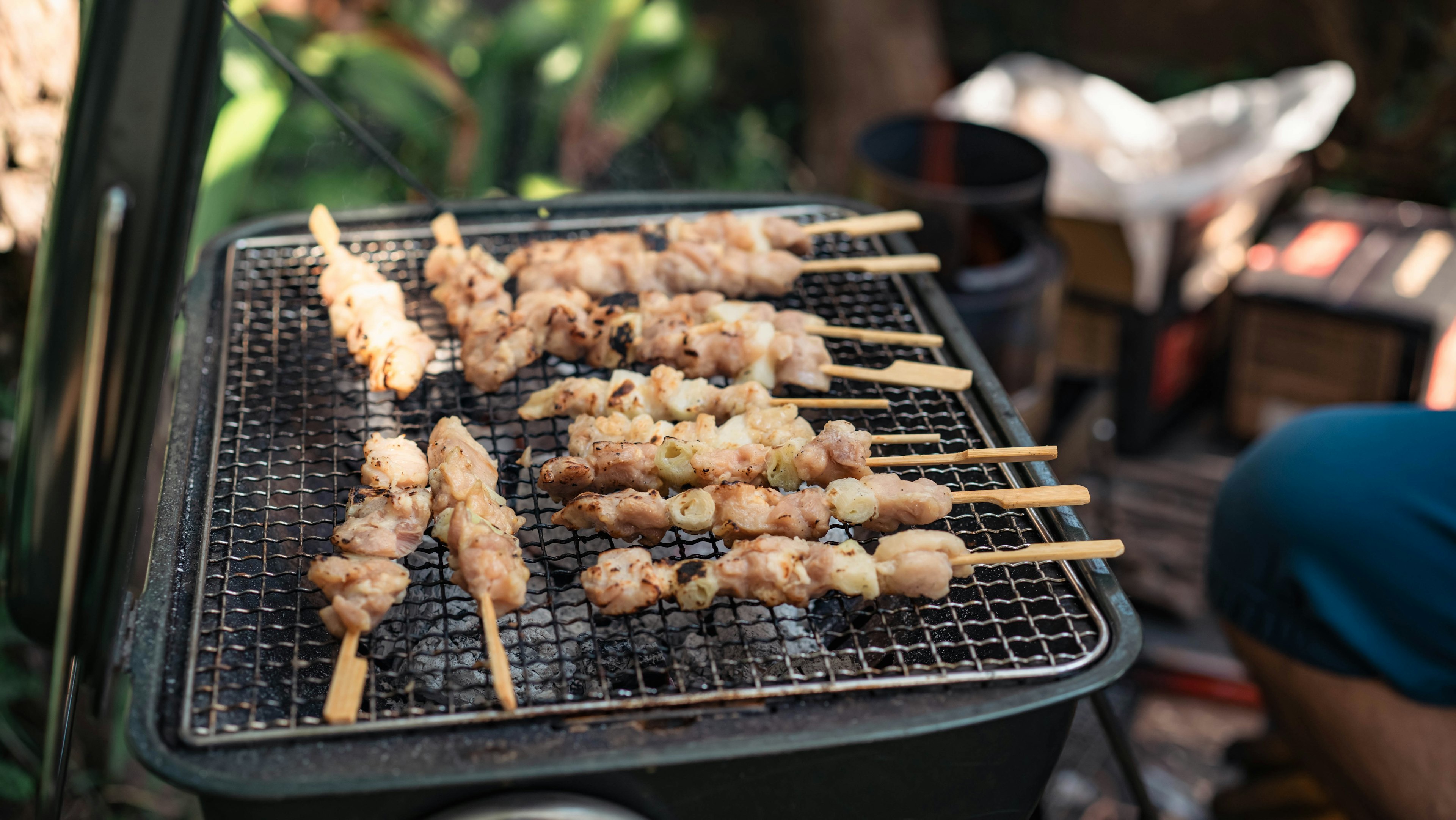 焼き鳥の串が網の上で焼かれている風景