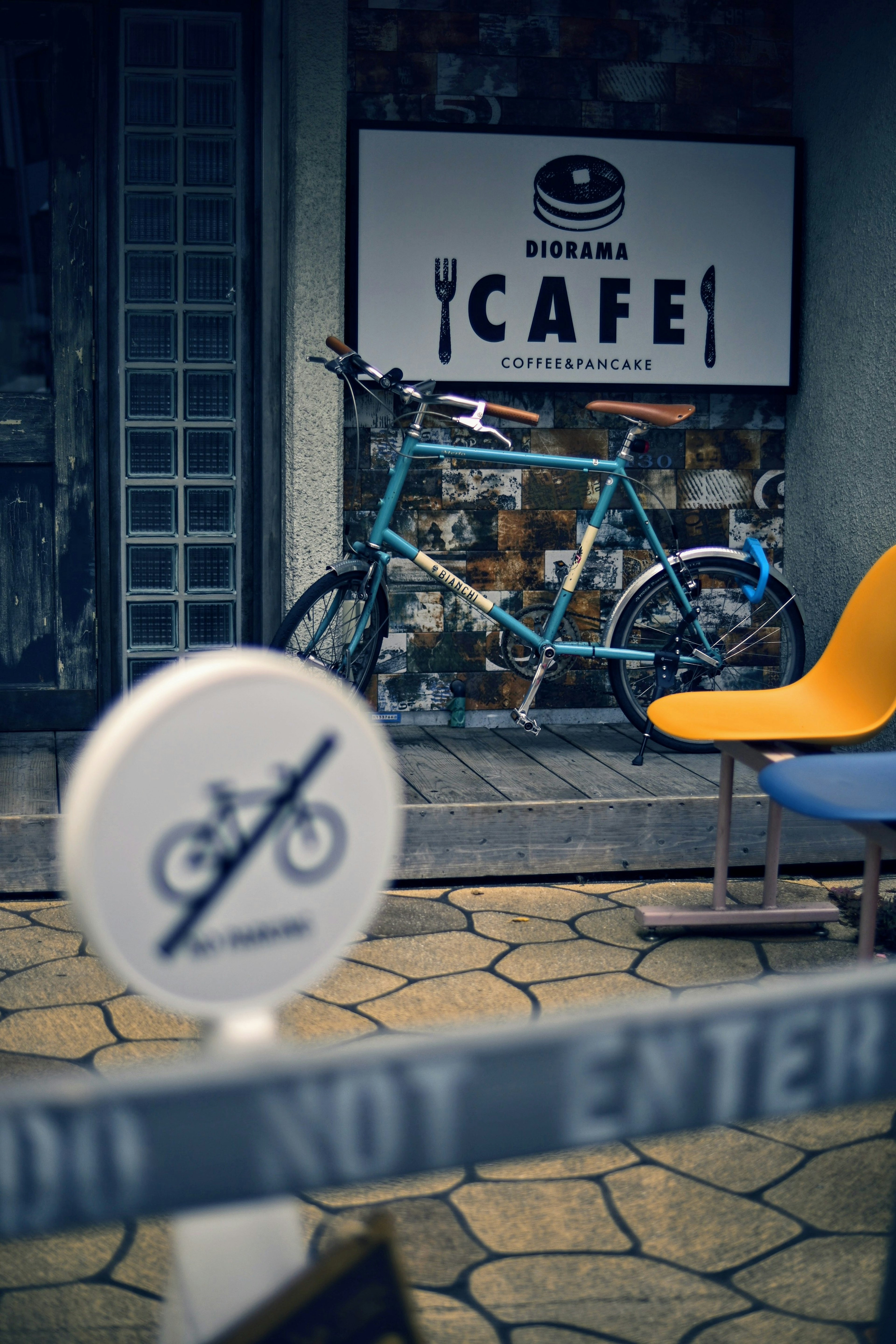 Sepeda biru di samping papan kafe dengan kursi modern