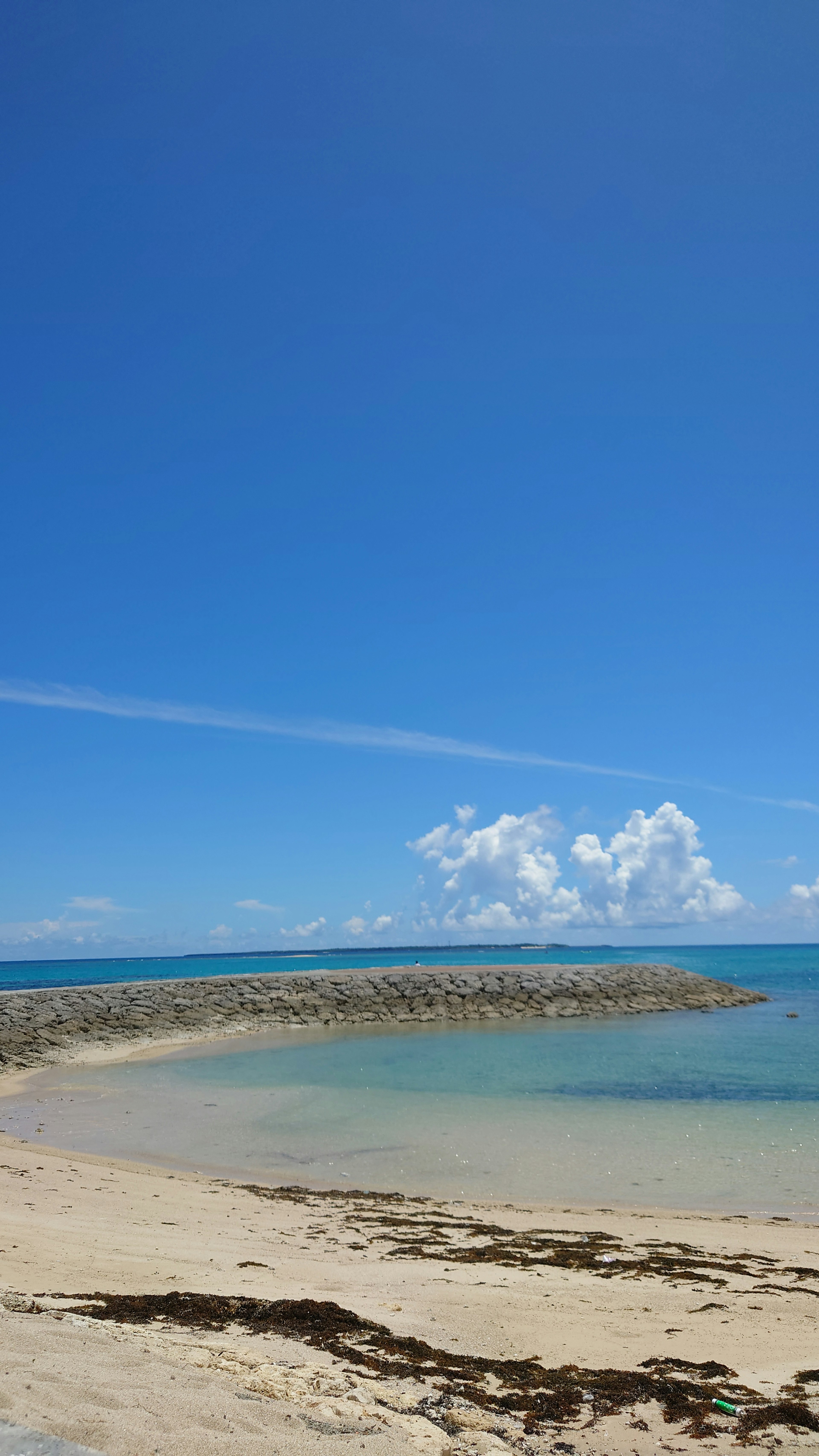 ทิวทัศน์ชายหาดที่สวยงามพร้อมท้องฟ้าสีฟ้าและเมฆขาว