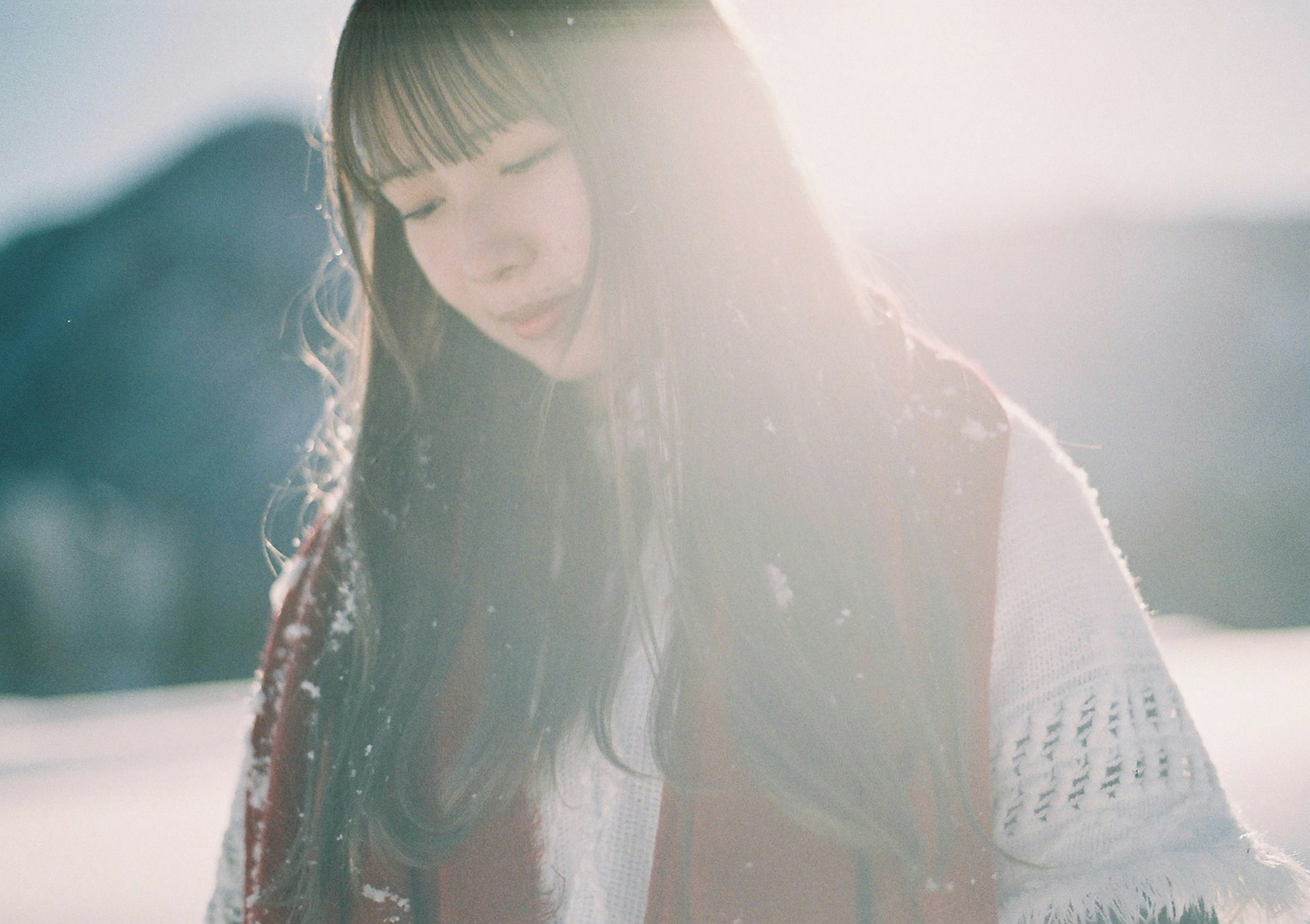 Young woman gracefully smiling in the snow soft light surrounding her