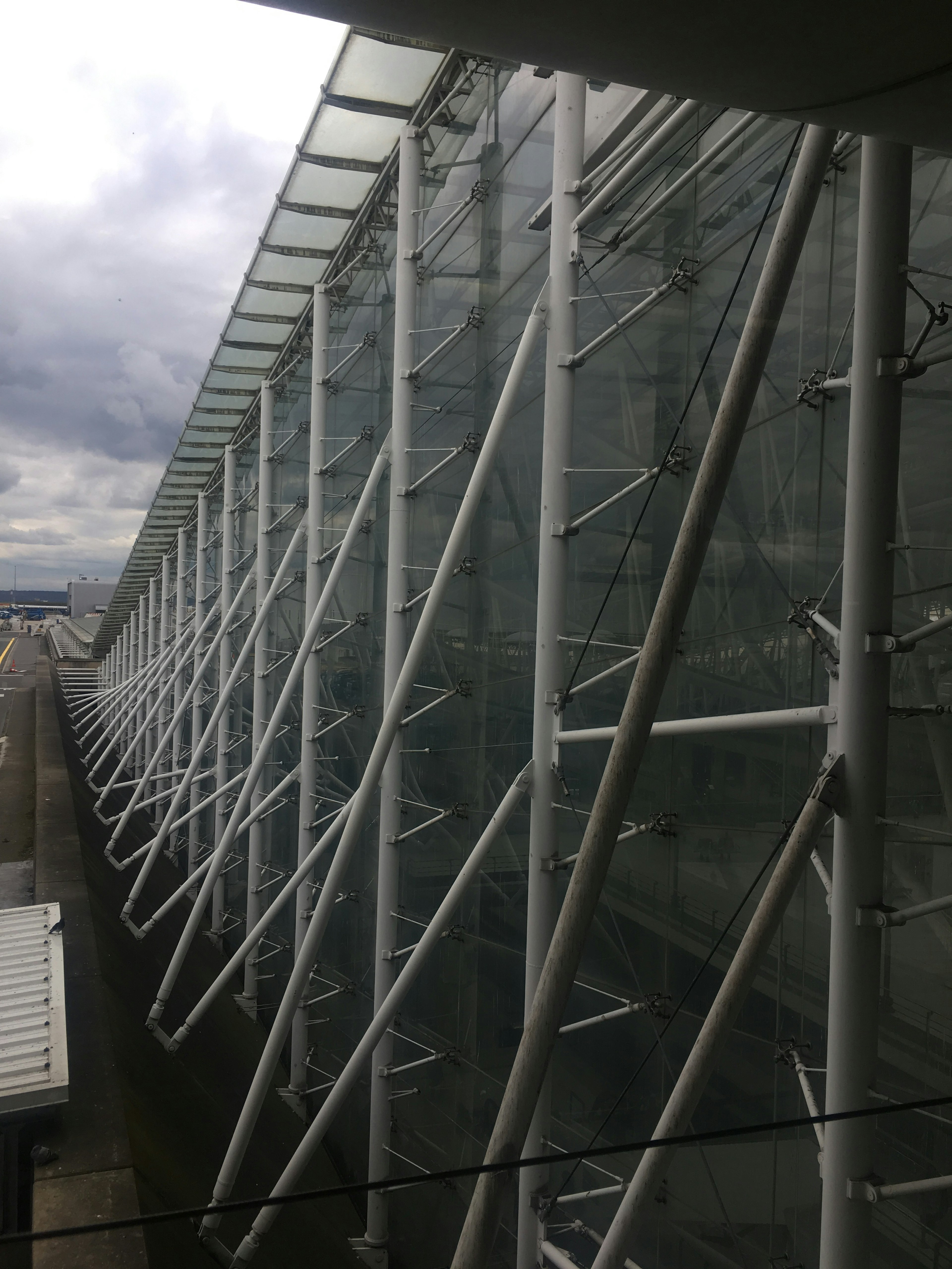 Fachada de edificio moderno con elementos estructurales de vidrio y blanco