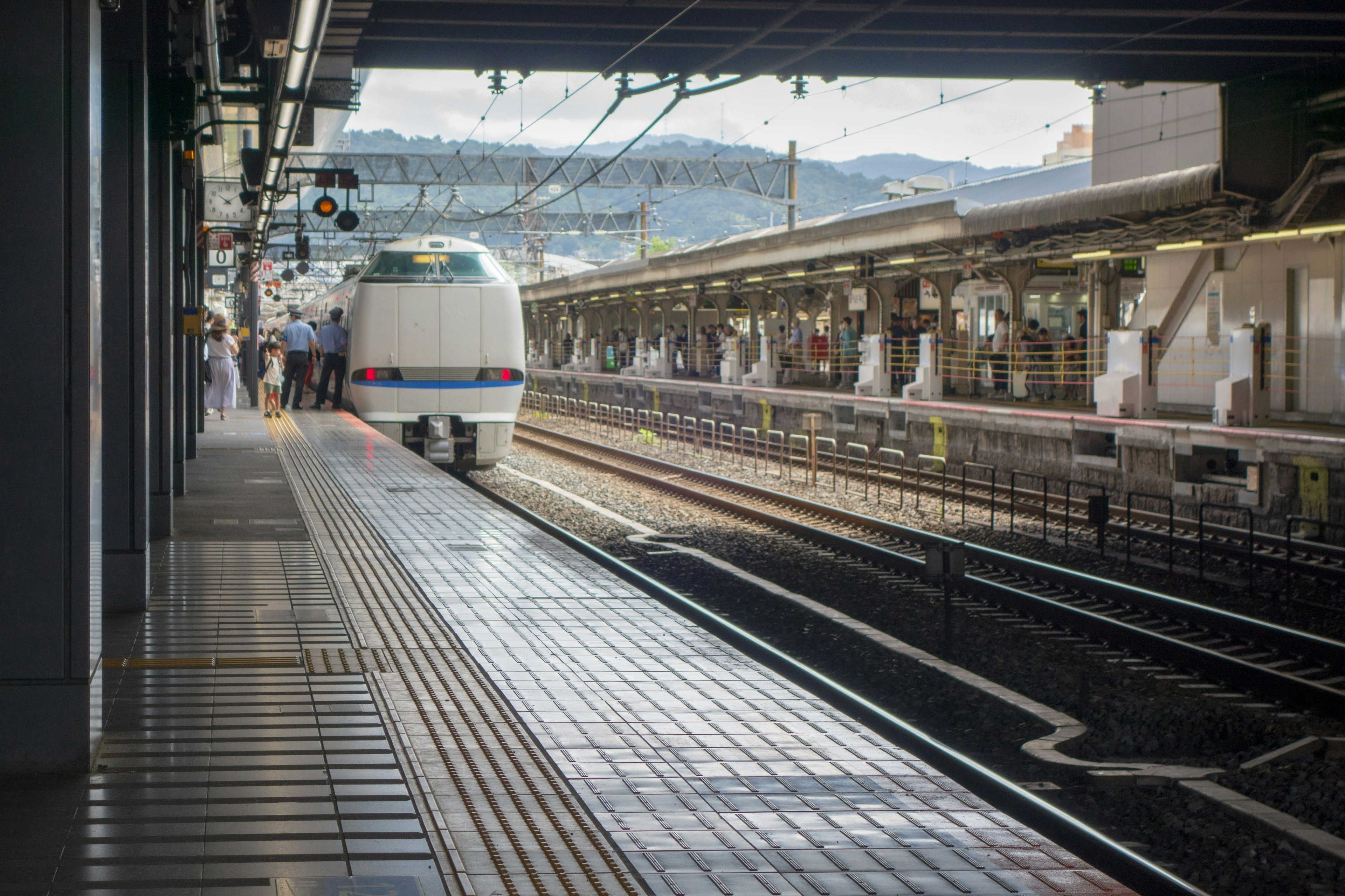 Vista de una plataforma con un tren Shinkansen llegando a una estación