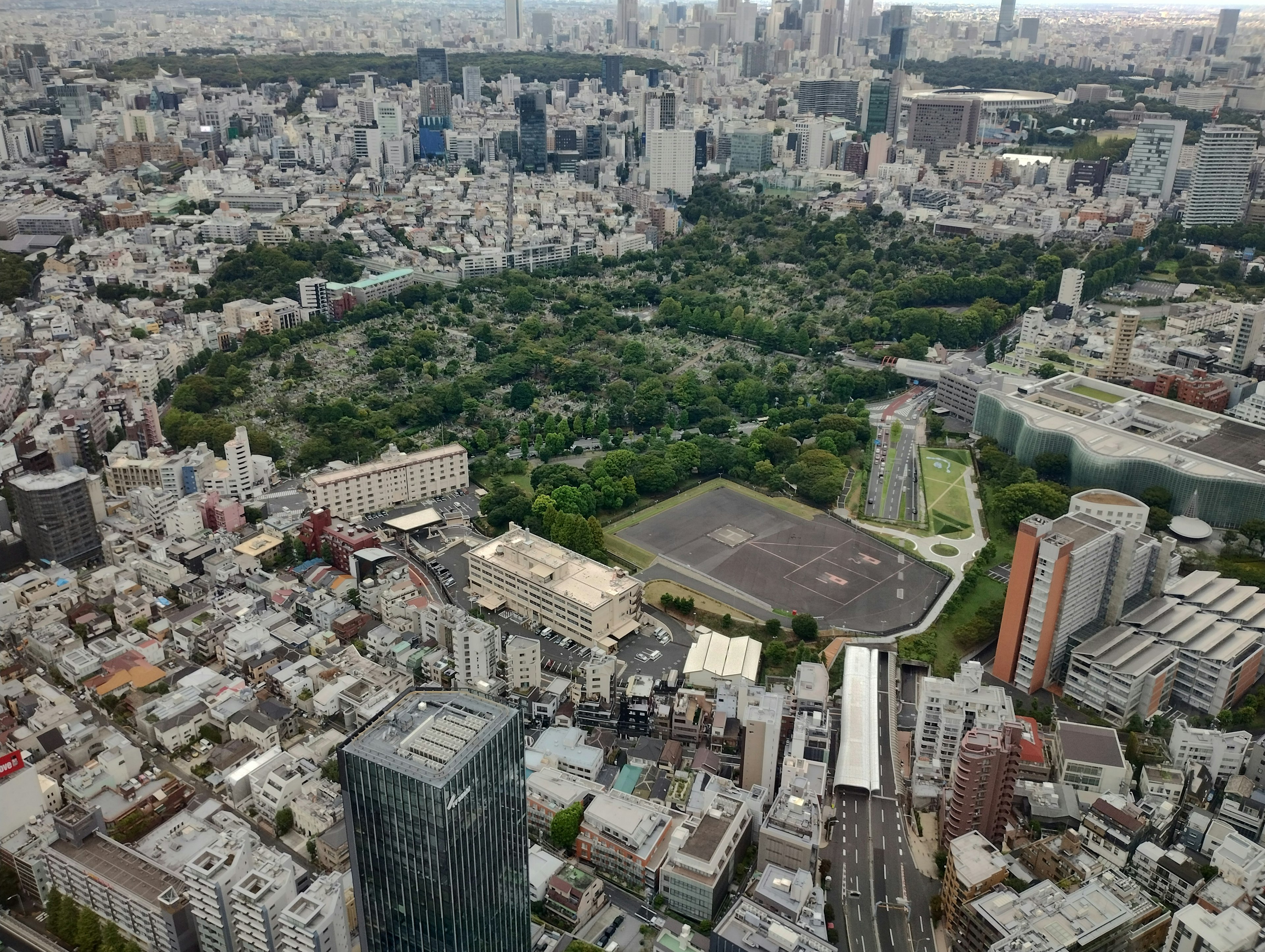 Aerial view of a large park surrounded by skyscrapers in Tokyo