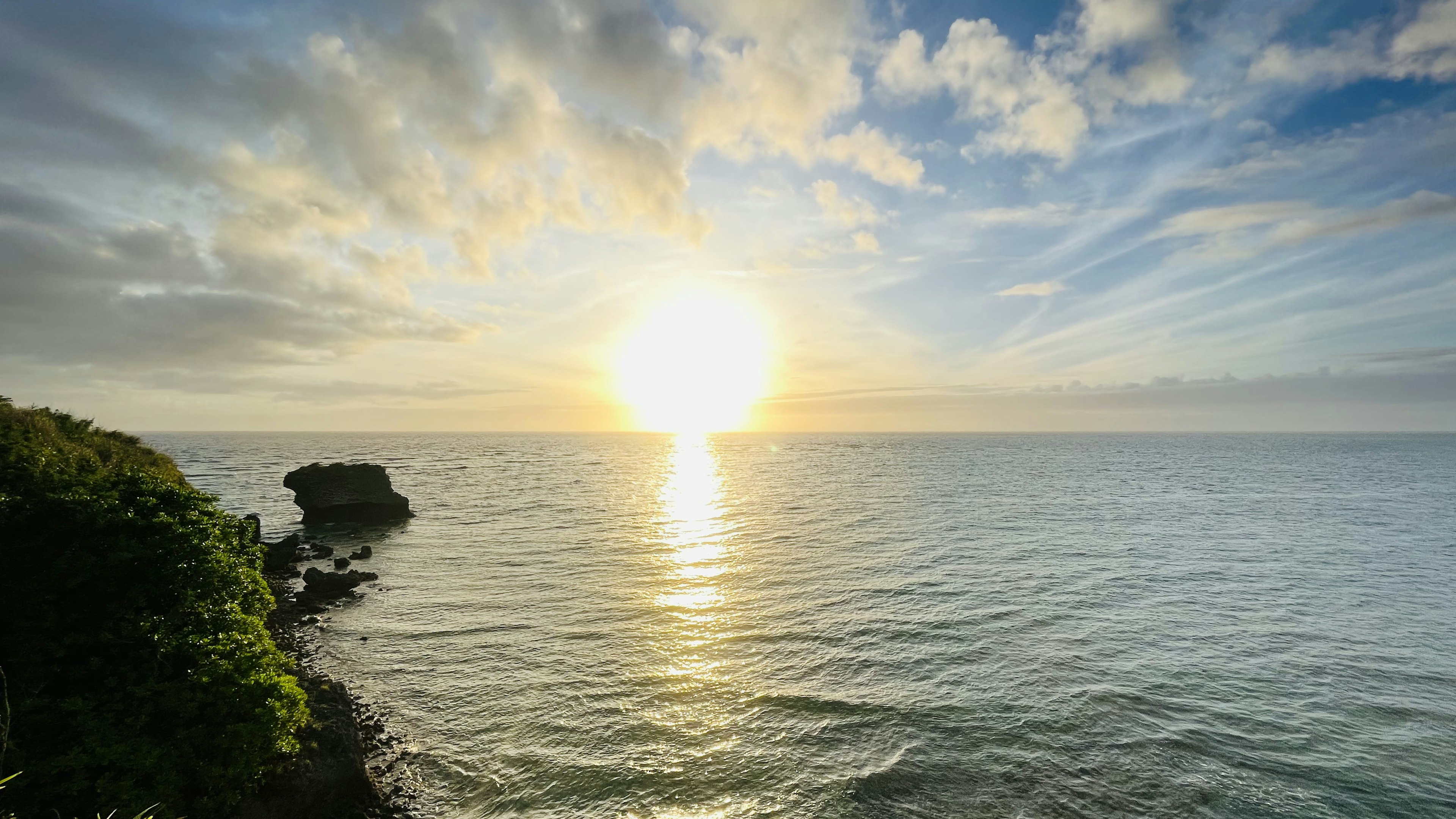 Schöne Meereslandschaft bei Sonnenaufgang mit Felsen und Grün