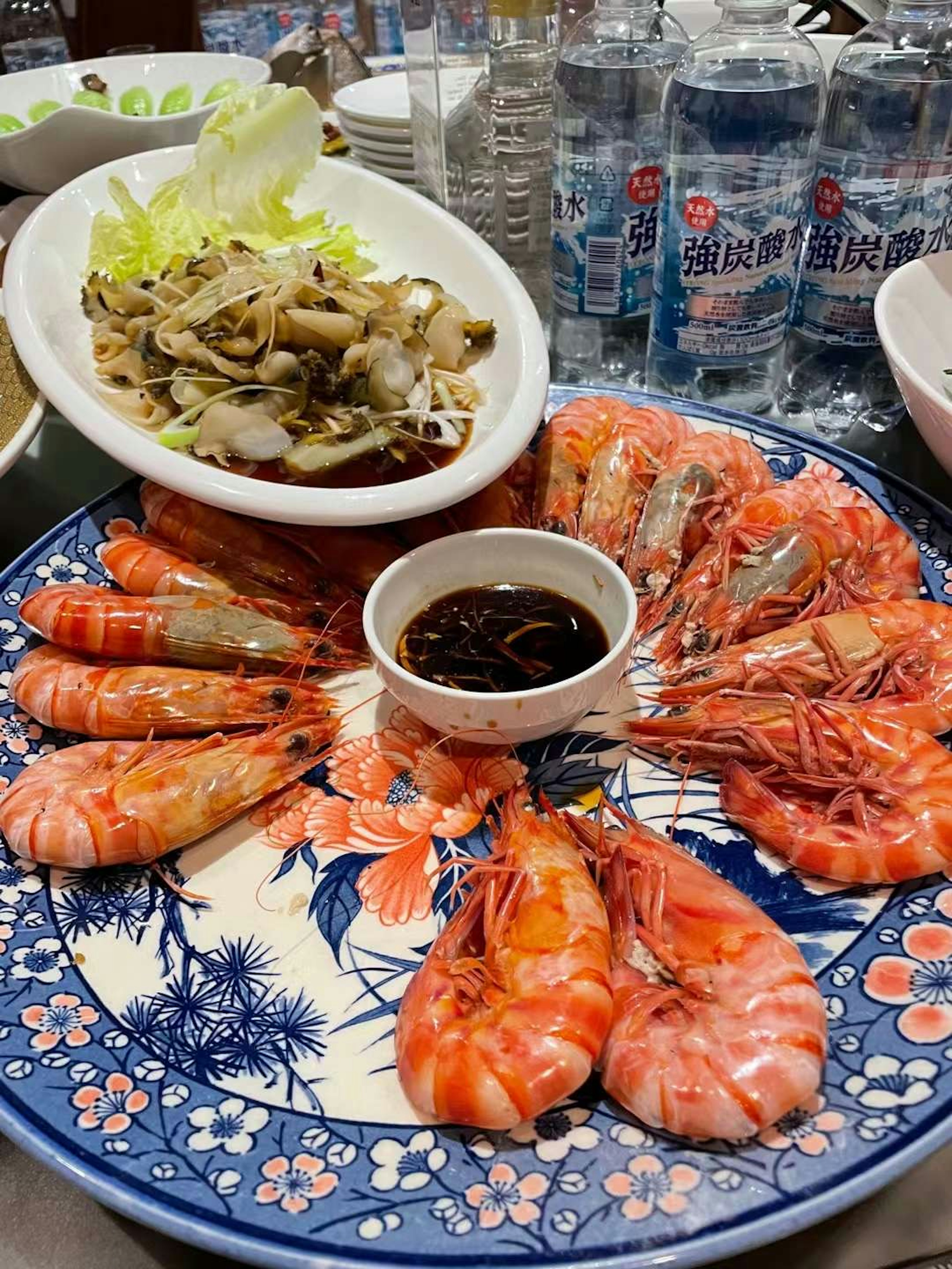 Un plato bellamente dispuesto de camarones coloridos con un acompañamiento de verduras