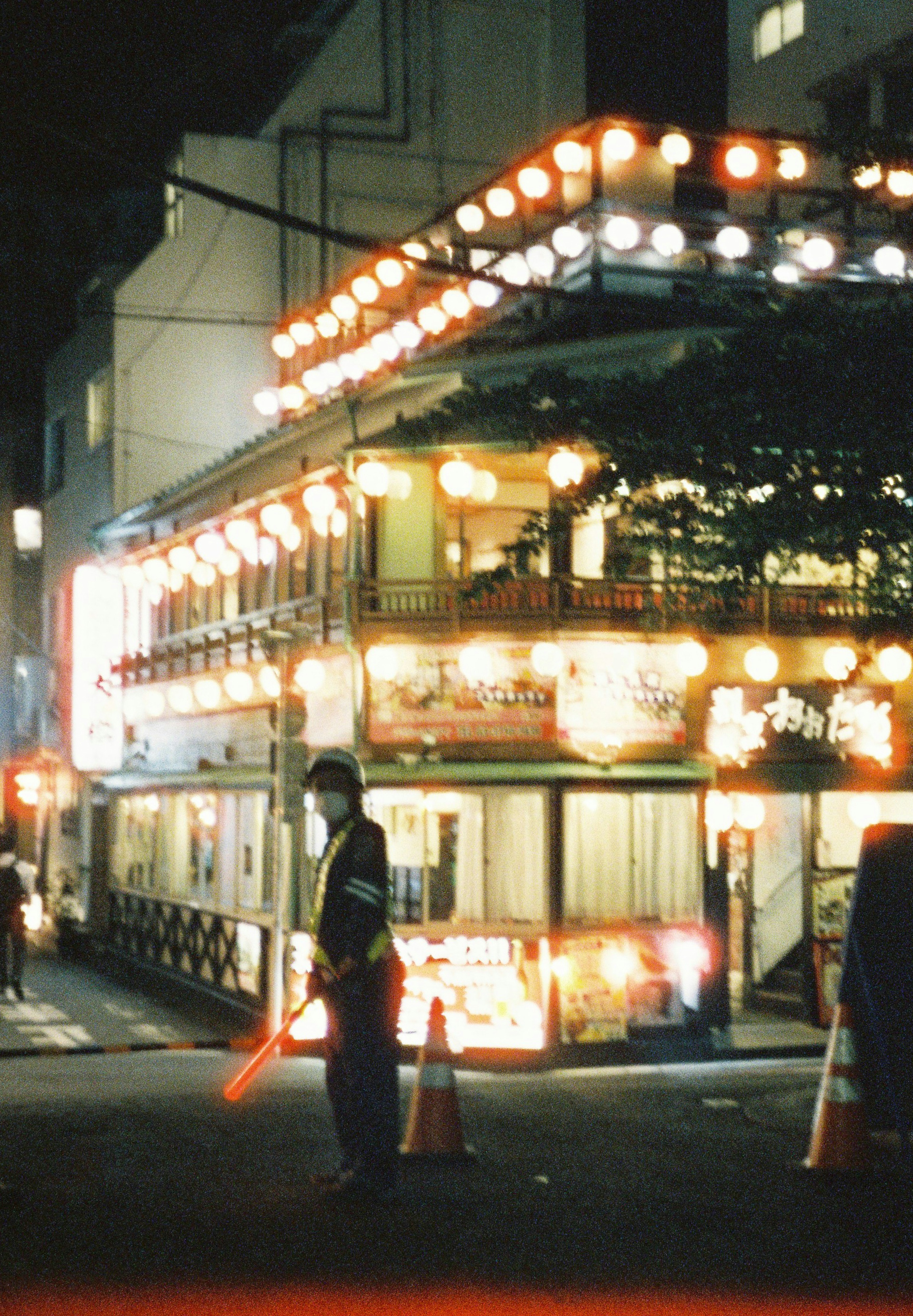 夜の街の光る提灯と警官のいる風景