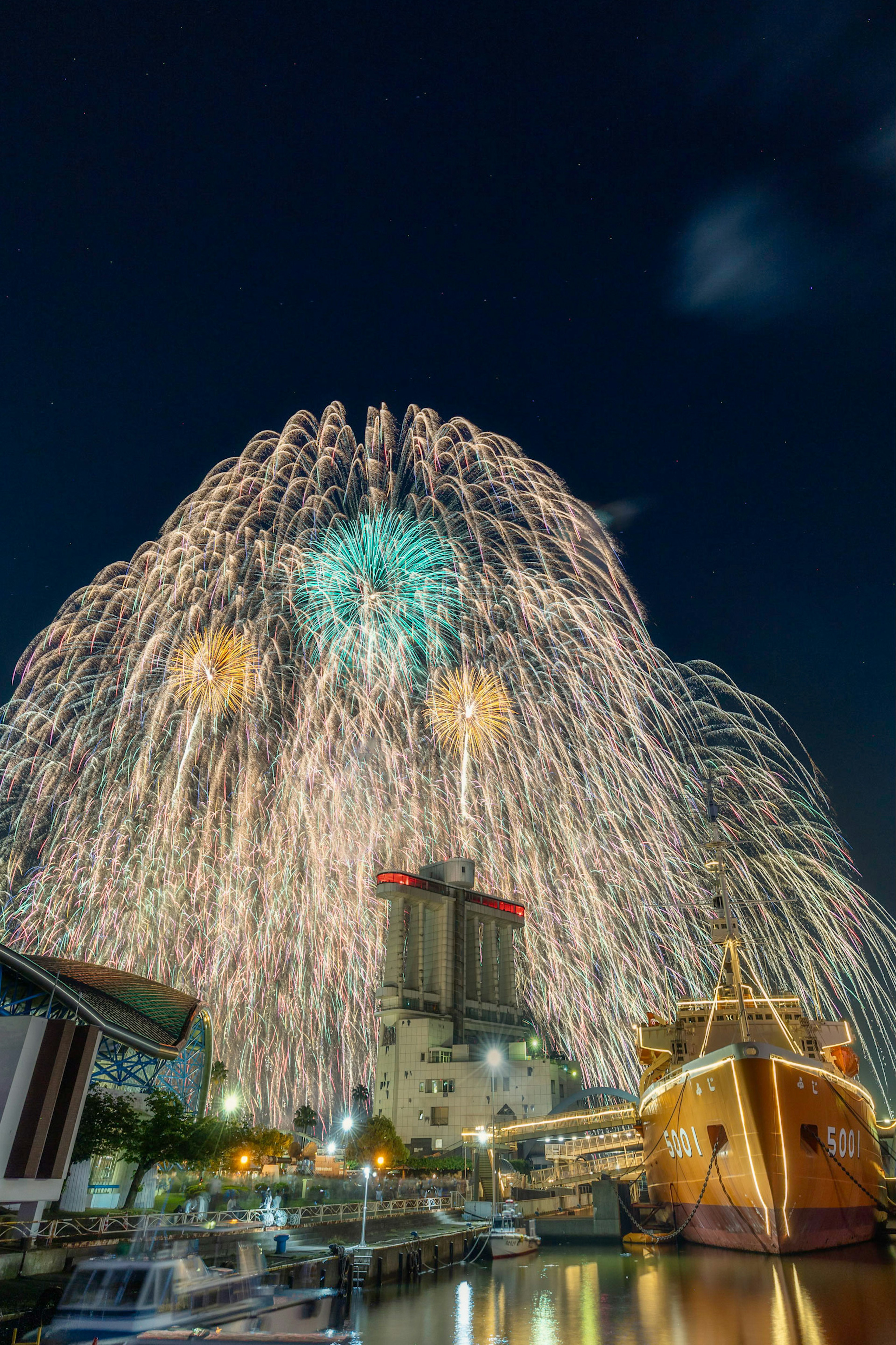 Feux d'artifice colorés éclatant au-dessus d'un port la nuit