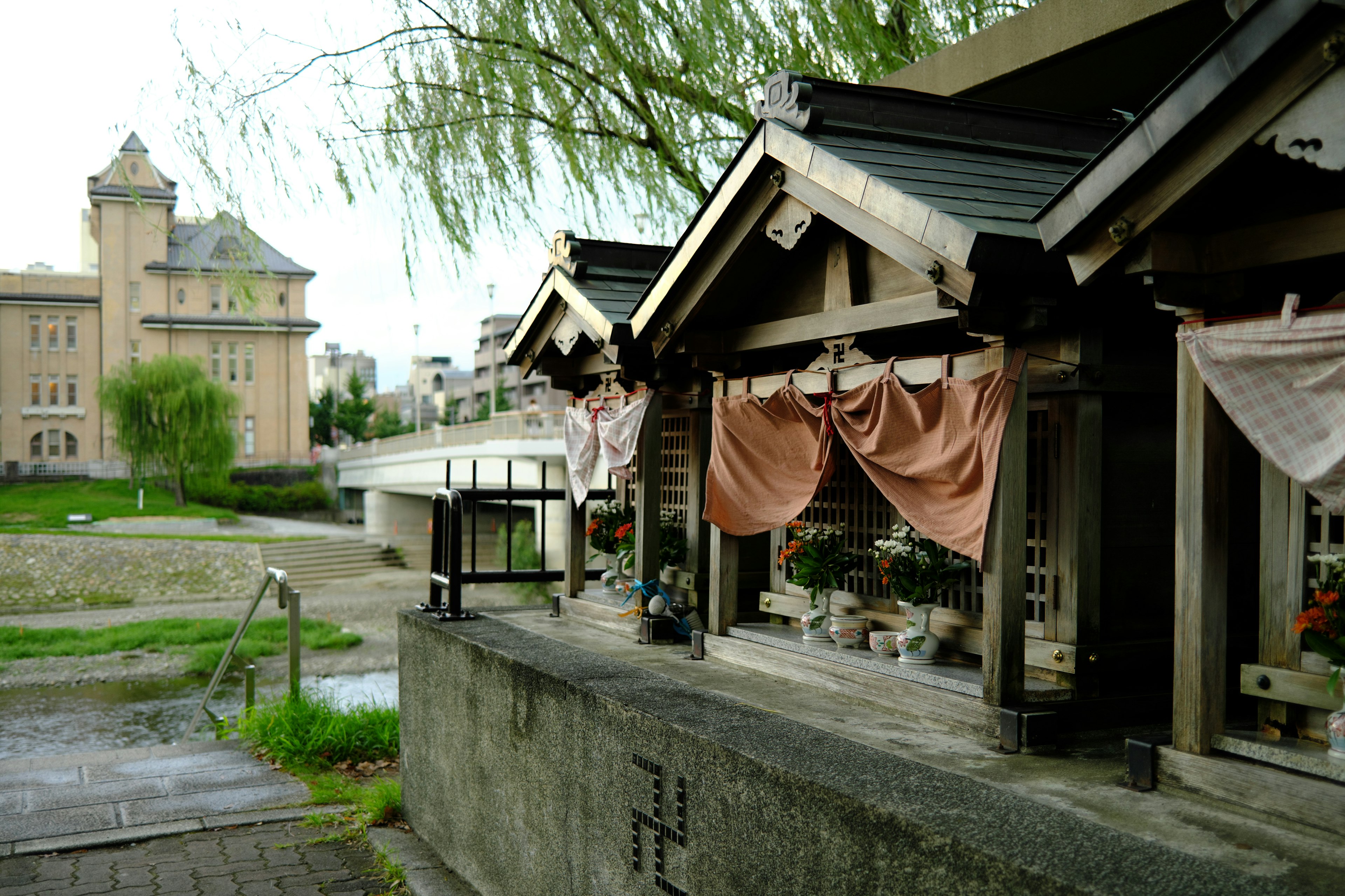 川沿いに並ぶ伝統的な日本の小屋と背景の建物