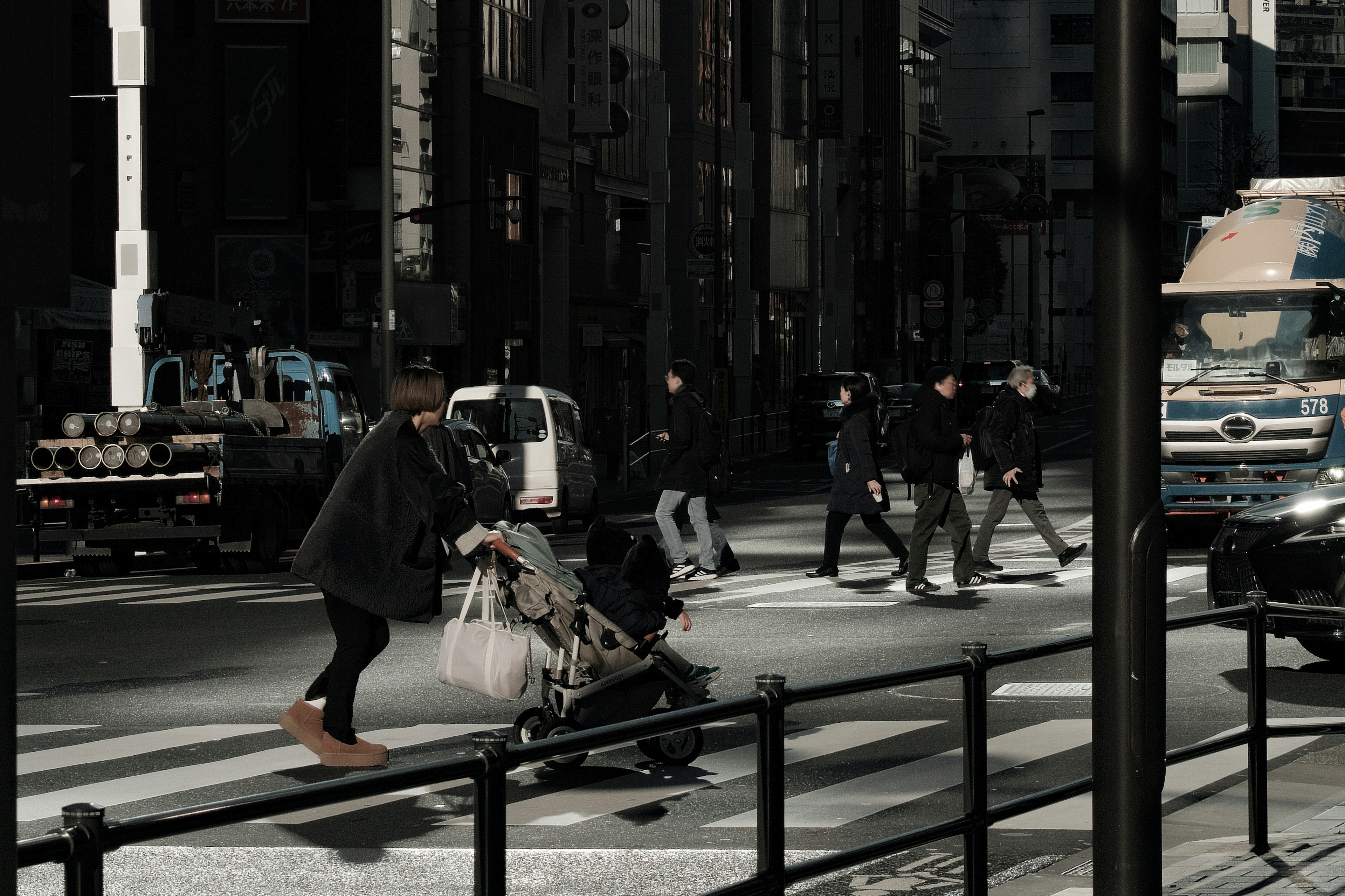 Scena di città con persone che attraversano un attraversamento pedonale donna che spinge un passeggino