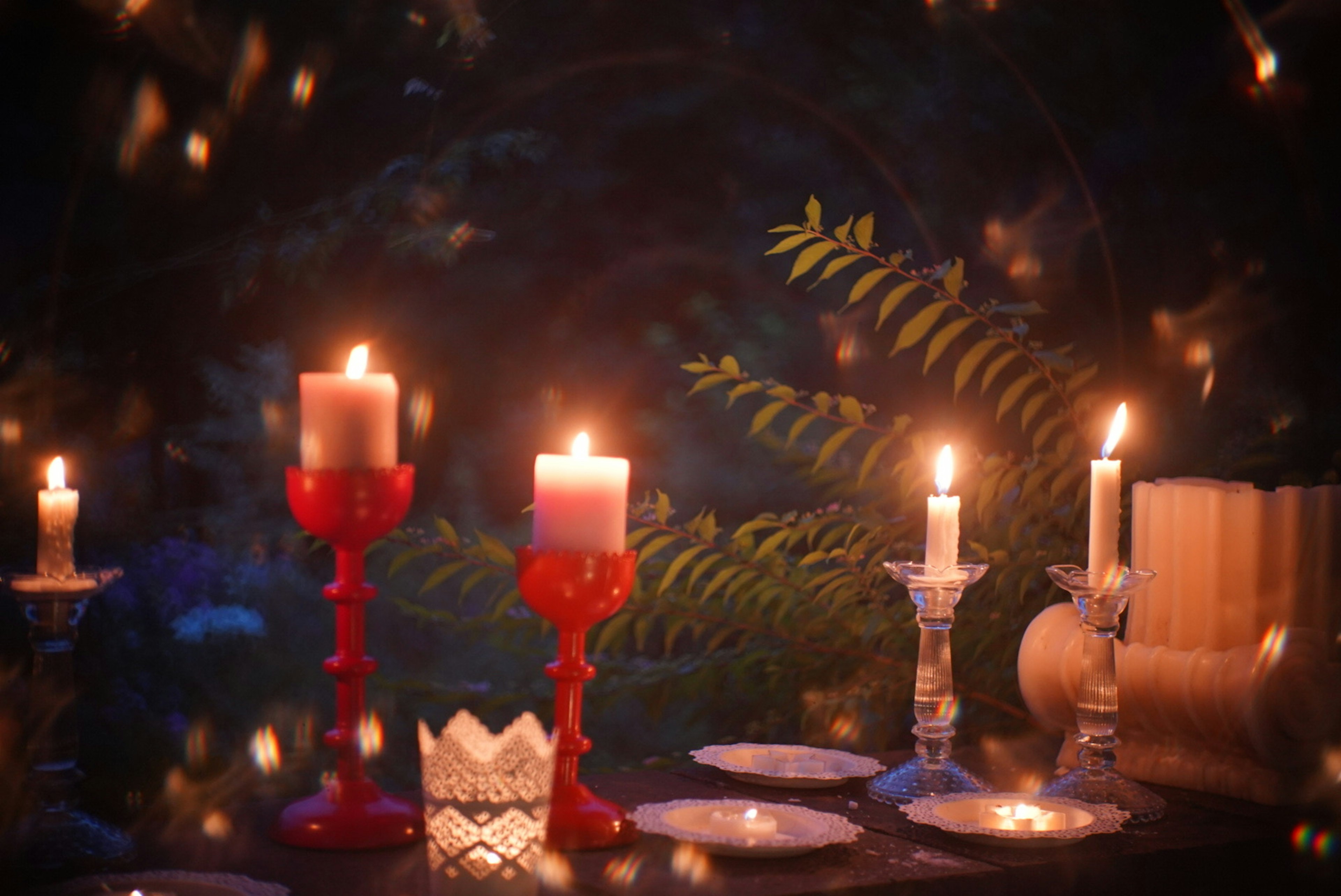 Romantic table setting with candles and green leaves